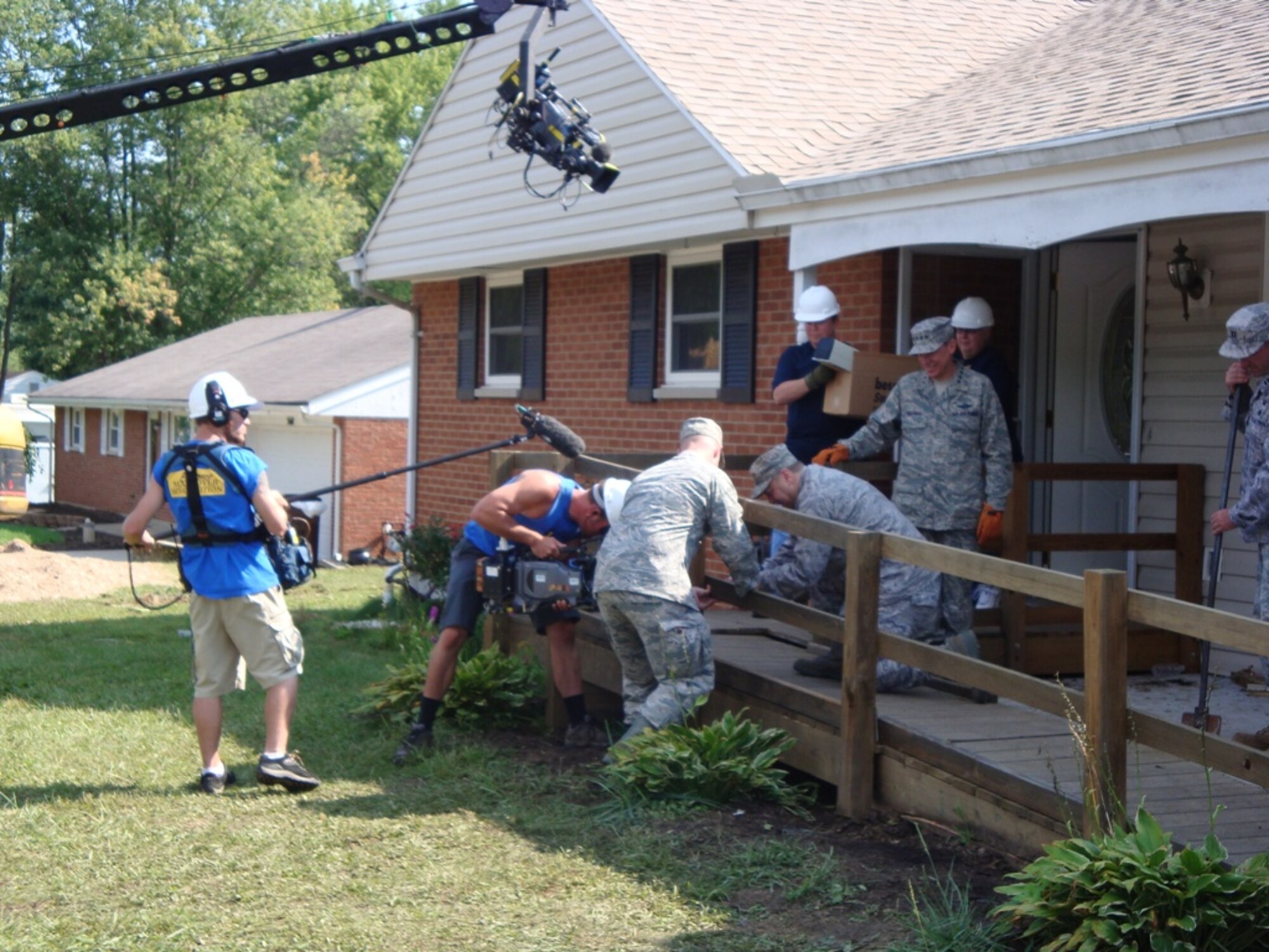 Air Force volunteers worked to remove a wheelchair ramp from the James
Terpenning home while "Extreme Makeover" camera crews videotaped the work.
(Air Force photo by Ron Fry)