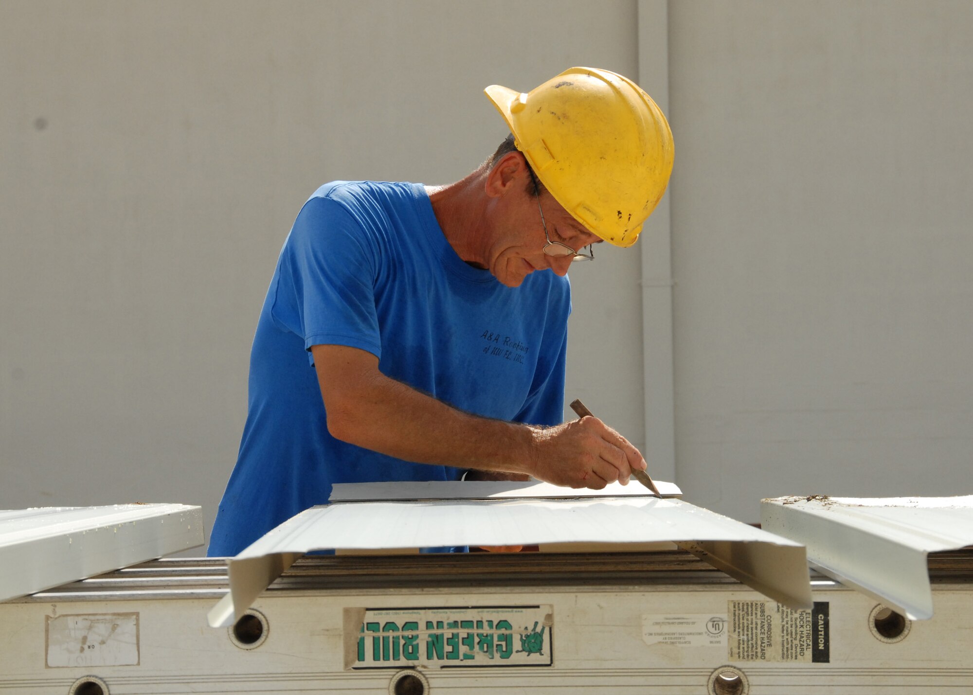 Jon Rector, R.L. Campbell Construction, marks the panels with a pencil before they are cut and trimmed to connect to each other as part of the roof of the 919th Logistics Readiness hangar Aug. 3 at Duke Field.  This is just one of many construction projects taking place at Duke Field.    (U.S. Air Force photo/Staff Sgt. Samuel King Jr.)