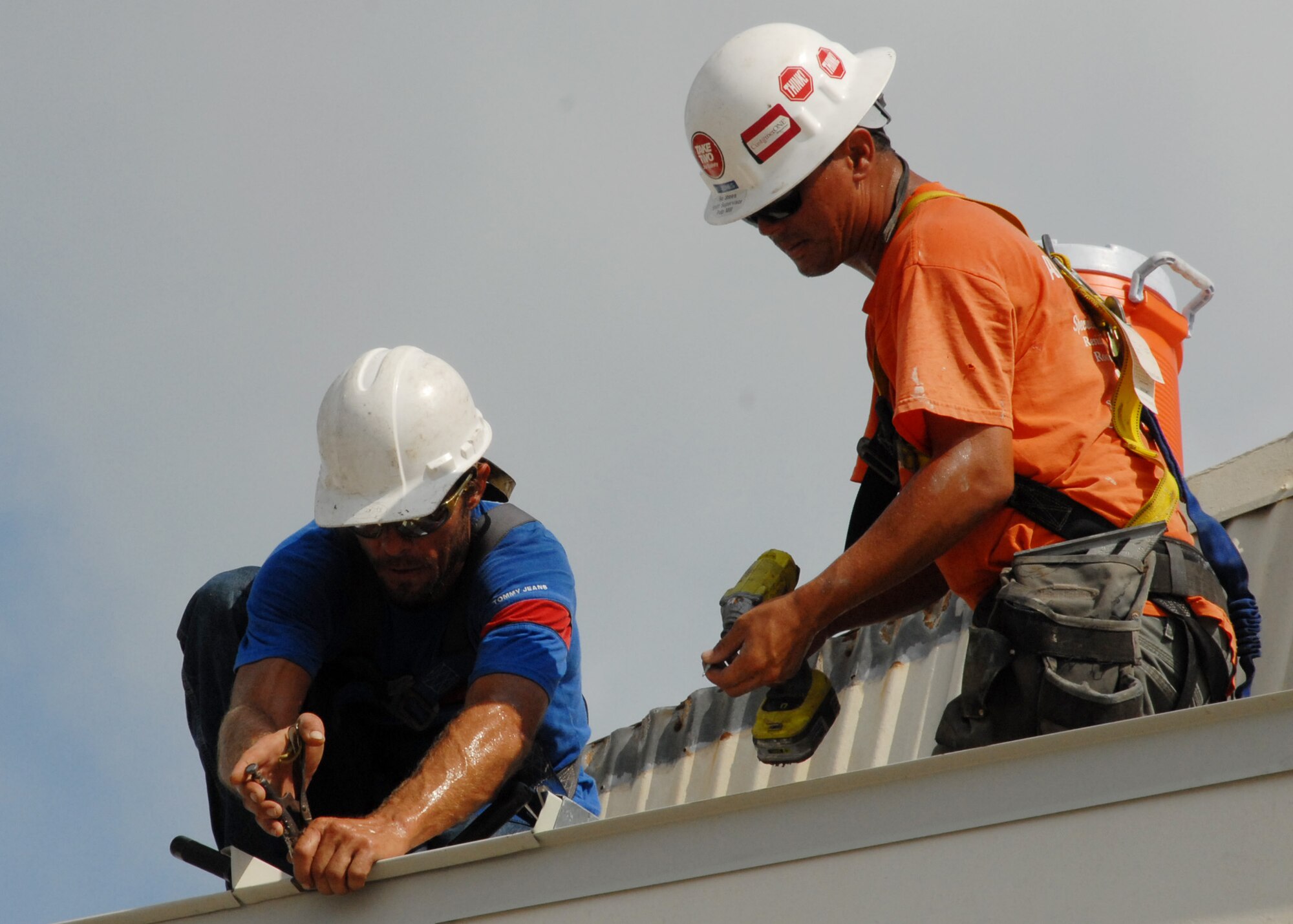 Members of R.L. Campbell Construction fasten panels to the top of the roof of the 919th Logistics Readiness hangar Aug. 3 at Duke Field.  This is just one of many construction projects taking place at Duke Field.    (U.S. Air Force photo/Staff Sgt. Samuel King Jr.)