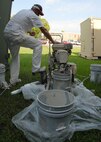 Mark Stedge, Washington Painting, pull-starts the paint sprayer before it is used to paint the top of the 919th Special Operations Group building Aug. 3 at Duke Field.  The painting crew is moving around repainting many of the base buildings.  (U.S. Air Force photo/Staff Sgt. Samuel King Jr.)