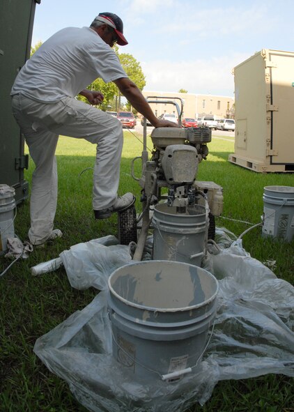 Mark Stedge, Washington Painting, pull-starts the paint sprayer before it is used to paint the top of the 919th Special Operations Group building Aug. 3 at Duke Field.  The painting crew is moving around repainting many of the base buildings.  (U.S. Air Force photo/Staff Sgt. Samuel King Jr.)