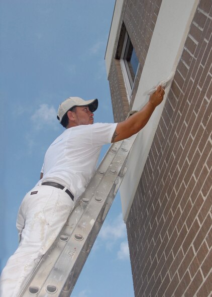 Marvin Miranda, Washington Painting, touches up the bottom of the trim of the 919th Special Operations Group building Aug. 3 at Duke Field.  The painting crew is moving around repainting many of the base buildings.  (U.S. Air Force photo/Staff Sgt. Samuel King Jr.)