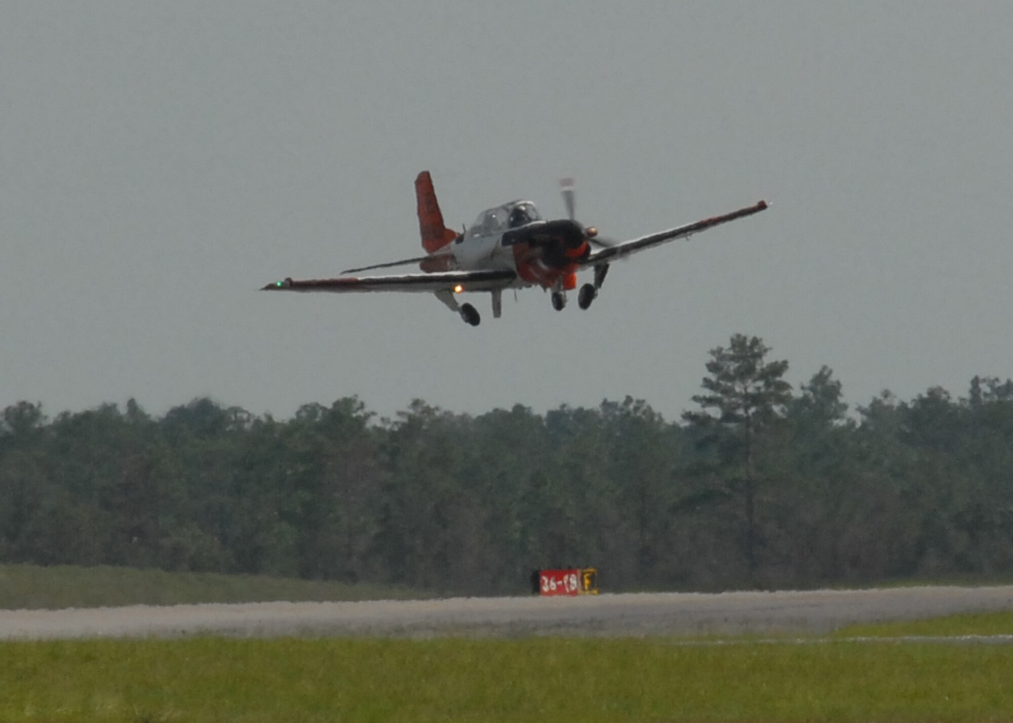 A Naval T-34 Turbo Mentor, performs a touch-n-go procedure over the Duke Field runway Aug. 3.  The training aircraft is used at NAS Whiting Field, but occasionally performs approaches here.  NAS Whiting Field also provides training for U.S. Marine Corps, Coast Guard, and Air Force student pilots, as well as several allied nations.  (U.S. Air Force photo/Staff Sgt. Samuel King Jr.)