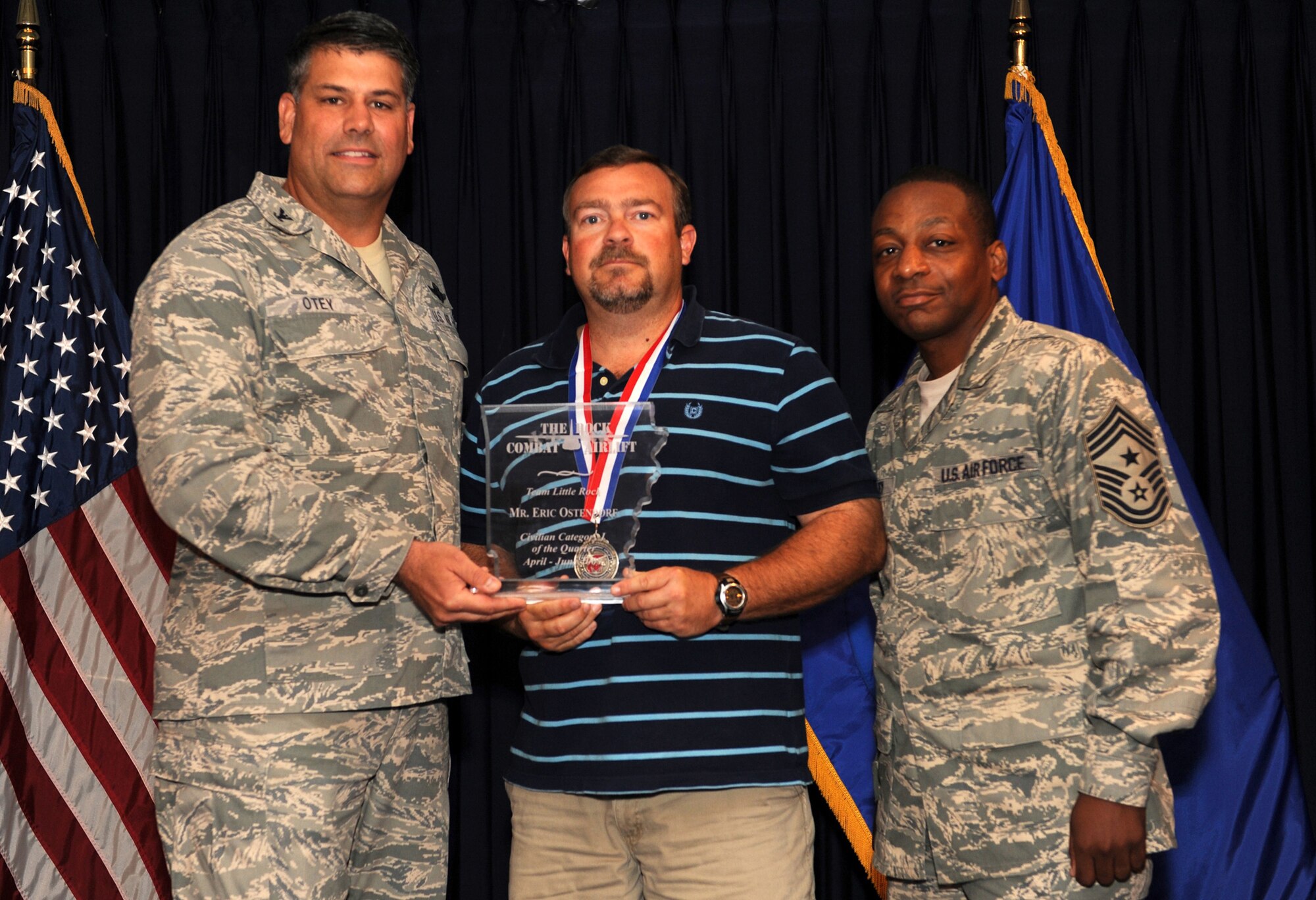 Col. Greg Otey, 19th Airlift Wing commander, and Chief Master Sgt. Anthony Brinkley, 19th Airlift Wing command chief, presents Eric Ostendorf, 19th Civil Engineer Squadron, quarterly award for civilian category 1 at Little Rock Air Force Base, Ark. July 30. (U. S. Air Force photo by Senior Airman Jim Araos)