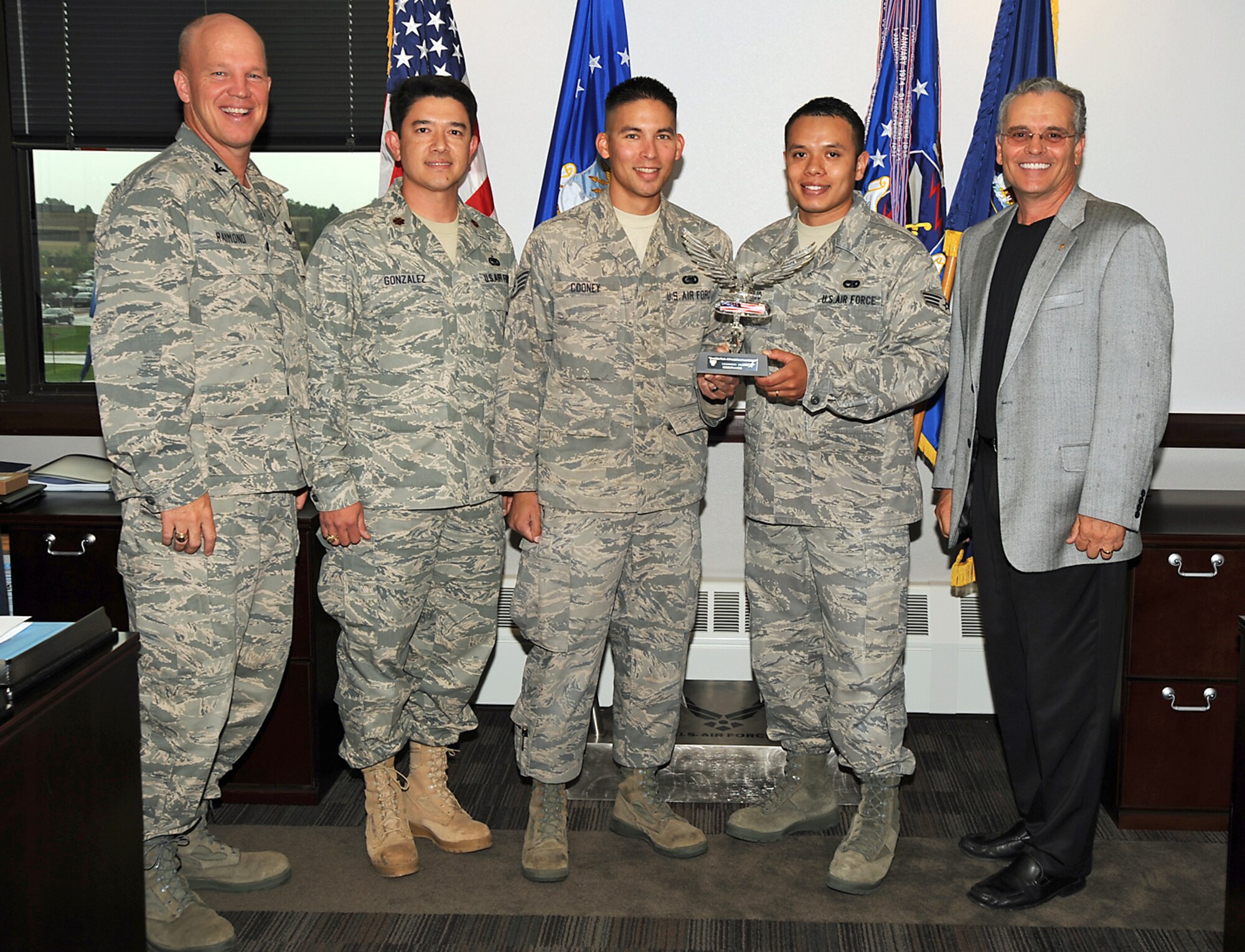 PETERSON AIR FORCE BASE, Colo. -- Col. Jay Raymond (left), 21st Space Wing commander, stands with (from left to right) Maj. Jerry Gonzalez, 21st Logistics Readiness Squadron commander, Staff Sgt. Justin Conley, 21st LRS, Senior Airman Guillermo Araujo, 21st LRS, and Tom Cavalli, president of the Lance P. Sijan Chapter of the Air Force Association, July 29. Mr. Cavalli presented the 21st LRS with the Sijan Award for helping facilitate the 2009 Tops in Blue program by moving equipment from an aircraft to the Broadmooor Hotel in Colorado Springs. The Sijan Award recognized accomplishments of officers and enlisted members who demonstrate the highest qualities of leadership in the performance of their duties and in the conduct of their lives. (Air Force photo by Roberta MacDonald)