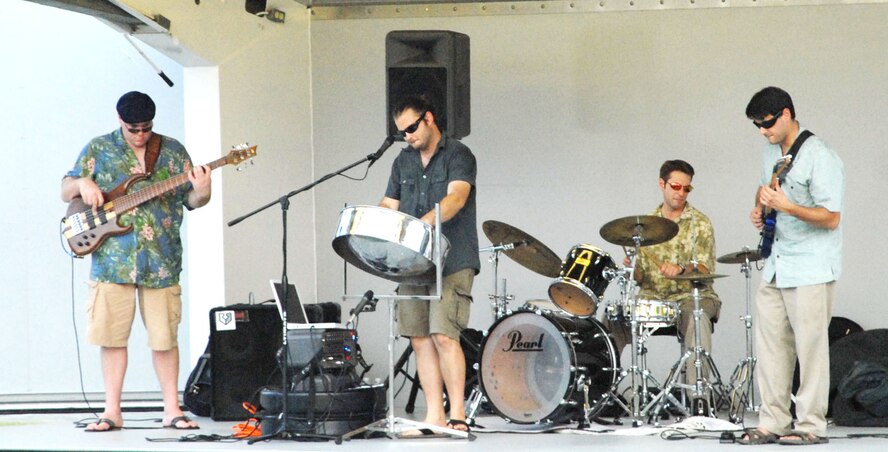 The Fe Band entertains the crowd with Caribbean sounds during 'A Night of Island Music,' an event sponsored by the 436th Force Support Squadron July 24 at Eagle Heights. The members of the band from left to right are Michael Carsley, bassist; Cort Farris, vocals and steel pan; Joe DiVita, drummer; and Ken Harmer, guitarist. (U.S. Air Force photo/Airman 1st Class Matthew Hubby)