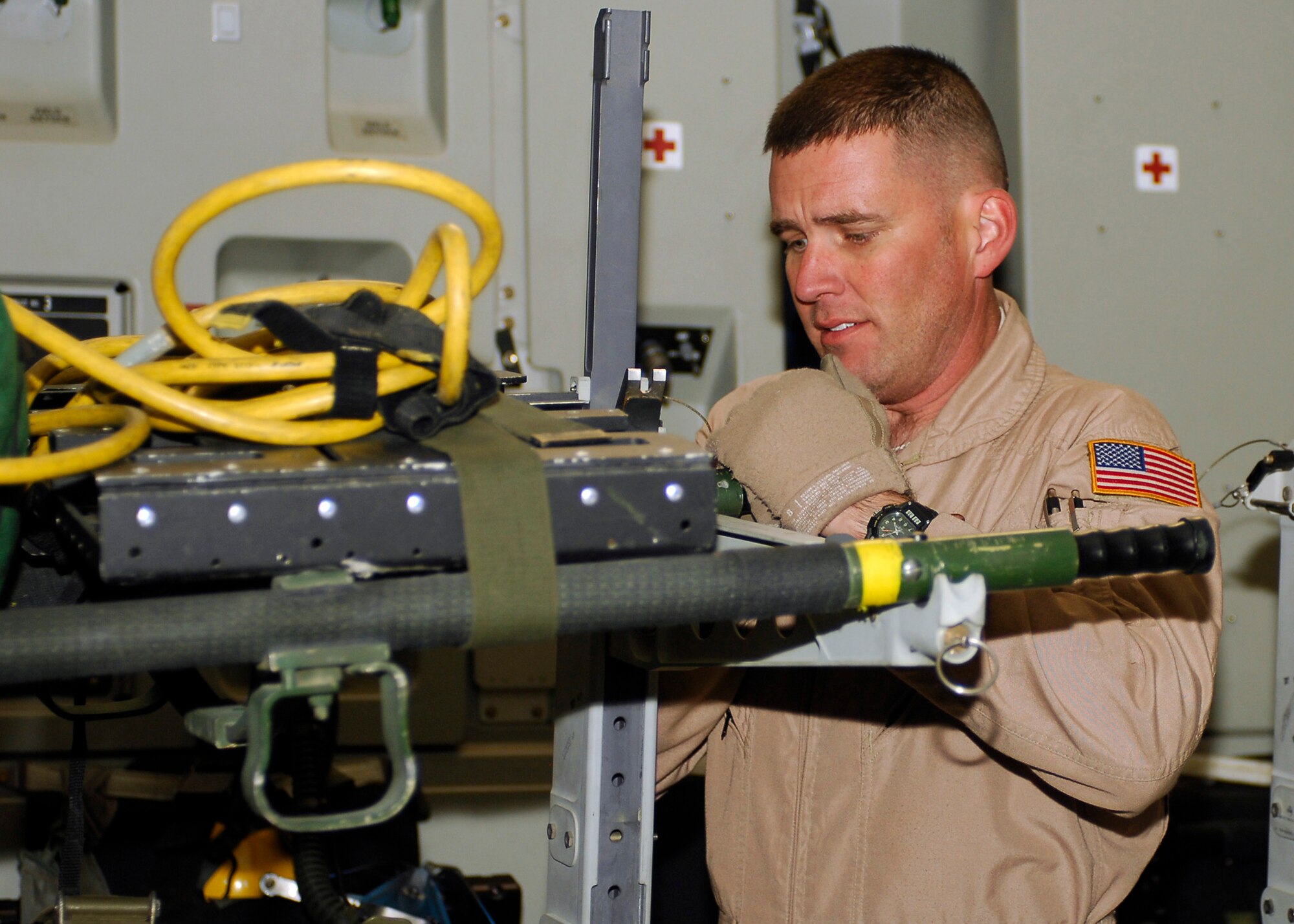 BAGRAM AIRFIELD, Afghanistan - Tech. Sgt. Todd Baldwin, from the 455th Expeditionary Aeromedical Evacuation Squadron, secures a litter in the C-17 Globemaster lll, here Aug. 4. Multiple litters were loaded onto the aircraft, full of medical equipment for the patients' flight to Landstuhl Regional Medical Center in Germany. Sergeant Baldwin is deployed from Charleston Air Force Base, S.C., and hails from Spartanburg, S.C. (U.S. Air Force photo/Senior Airman Felicia Juenke)