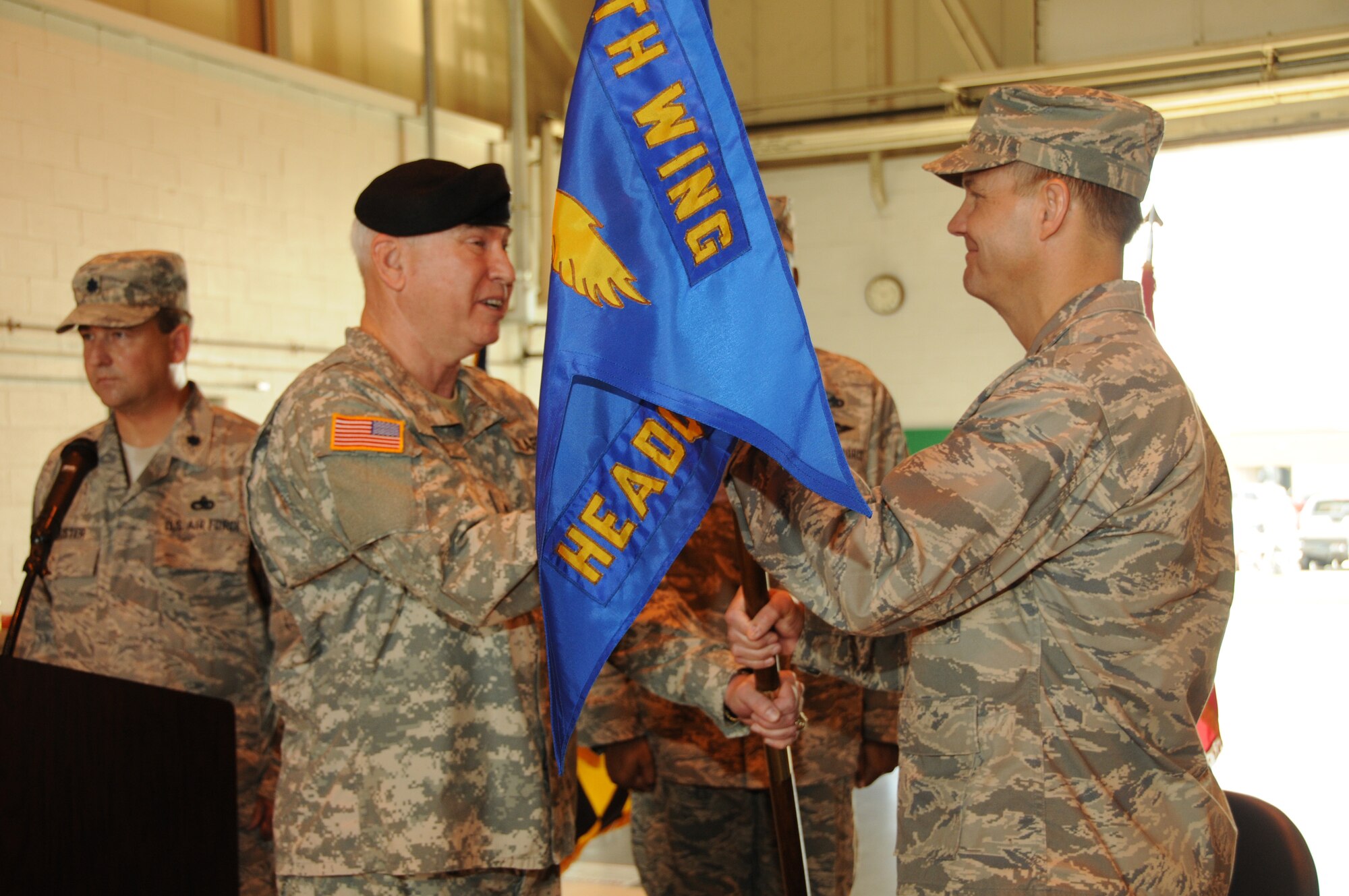 Brig. Gen. James A. Adkins, adjutant general of the Maryland National Guard, passes the 175th Wing Headquarters guidon to Col. Scott L. Kelly, commander of the 175th Wing, Maryland Air National Guard, during the wing assumption of command ceremony held at the Warfield Air National Guard Base on August 1, 2009.  (U.S. Air Force photo by TSgt. Chris Schepers/Released, 175th Wing/Public Affairs, WARFIELD AIR NATIONAL GUARD BASE, Maryland)