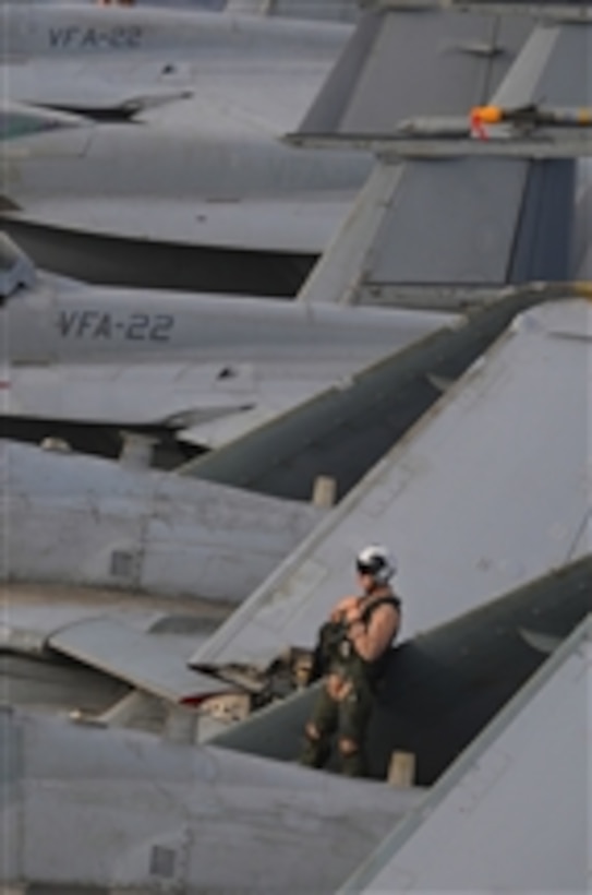 U.S. Navy Lt. Cmdr. James Shell leans on the wing of an EA-6B Prowler aircraft assigned to Tactical Electronic Warfare Squadron 139 before flight operations aboard the aircraft carrier USS Ronald Reagan (CVN 76) in the Gulf of Oman on July 18, 2009.  Prior to flight operations, squadron mechanics and pilots inspect their aircraft to ensure that all systems and parts are in working order.  The Ronald Reagan is deployed in the U.S. 5th Fleet area of operations.  