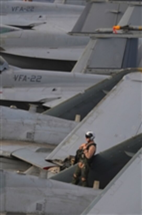 U.S. Navy Lt. Cmdr. James Shell leans on the wing of an EA-6B Prowler aircraft assigned to Tactical Electronic Warfare Squadron 139 before flight operations aboard the aircraft carrier USS Ronald Reagan (CVN 76) in the Gulf of Oman on July 18, 2009.  Prior to flight operations, squadron mechanics and pilots inspect their aircraft to ensure that all systems and parts are in working order.  The Ronald Reagan is deployed in the U.S. 5th Fleet area of operations.  