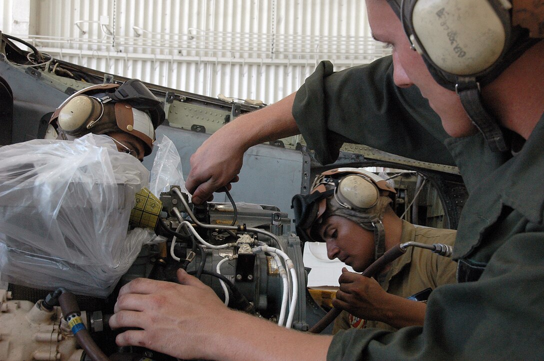 Lance Cpl. Aaron Neal, right, Lance Cpl. Manuel GarciaRamirez and Lance Cpl. Eddie Tapia, Marine Attack Squadron 311 powerline mechanics, prepare an AV-8B Harrier engine to be reinstalled into a Harrier after maintenance in the squadron’s hangar at the Marine Corps Air Station in Yuma, Ariz., Aug. 4, 2009. The squadron was named the attack squadron of the year by the Marine Corps Aviation Association July 28, 2009, for its constant mission readiness and overall performance at home and on deployments. The Tomcats beat out six other squadrons to earn the title, which they have received three times before.