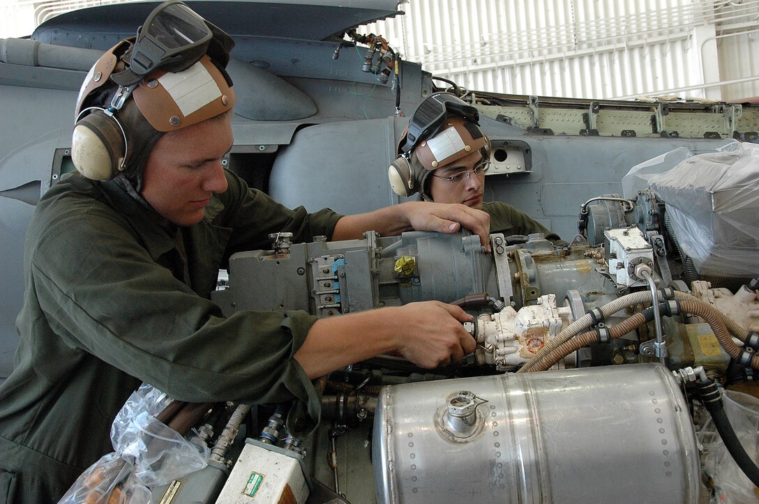 Lance Cpl. Aaron Neal, left, and Lance Cpl. Eddie Tapia, Marine Attack Squadron 311 powerline mechanics, prepare an AV-8B Harrier engine to be reinstalled into a Harrier after maintenance in the squadron’s hangar at the Marine Corps Air Station in Yuma, Ariz., Aug. 4, 2009. The squadron was named the attack squadron of the year by the Marine Corps Aviation Association July 28, 2009, for its constant mission readiness and overall performance at home and on deployments. The Tomcats beat out six other squadrons to earn the title, which they have received three times before.