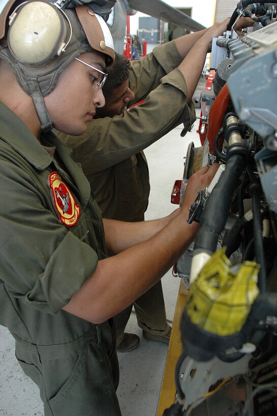 Lance Cpl. Eddie Tapia, left, and Lance Cpl. Manuel GarciaRamirez, Marine Attack Squadron 311 powerline mechanics, prepare an AV-8B Harrier engine to be reinstalled into a Harrier after maintenance in the squadron’s hangar at the Marine Corps Air Station in Yuma, Ariz., Aug. 4, 2009. The squadron was named the attack squadron of the year by the Marine Corps Aviation Association July 28, 2009, for its constant mission readiness and overall performance at home and on deployments. The Tomcats beat out six other squadrons to earn the title, which they have received three times before.