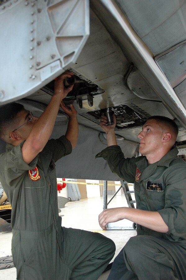 Lance Cpl. Eddie Tapia, left, and Lance Cpl. Aaron Neal, Marine Attack Squadron 311 powerline mechanics, inspect an AV-8B Harrier in the squadron’s hangar at the Marine Corps Air Station in Yuma, Ariz., Aug. 4, 2009. The squadron was named the attack squadron of the year by the Marine Corps Aviation Association July 28, 2009, for its constant mission readiness and overall performance at home and on deployments. The Tomcats topped six other squadrons to earn the title, which they have received three times before.