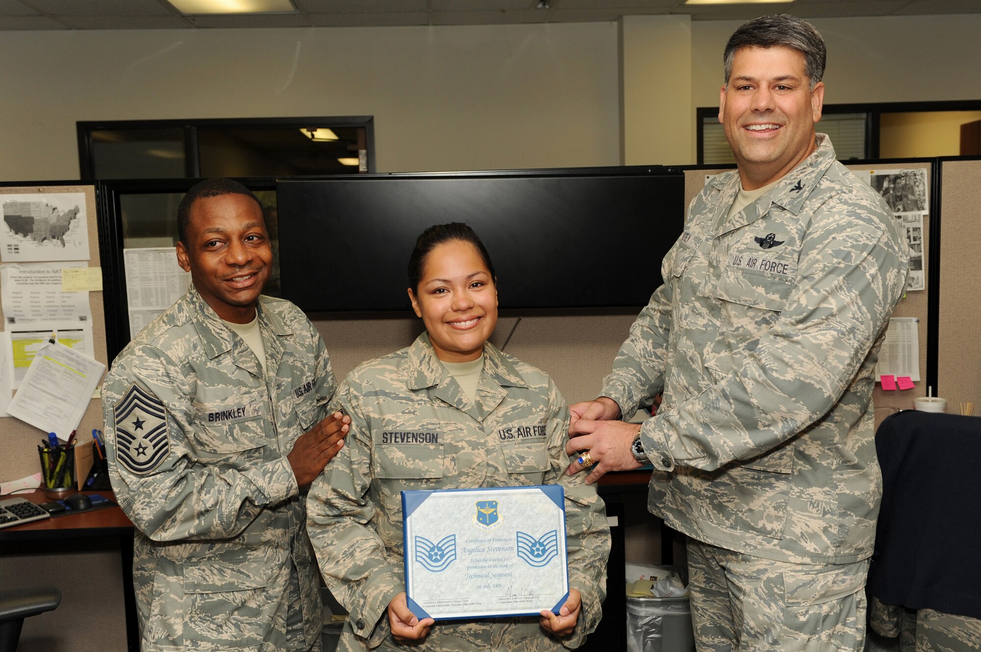 Col. Greg Otey (right), 19th Airlift Wing commander, and Chief Master Sgt. Anthony Brinkley (left), 19th Airlift Wing command chief, step promote Staff Sgt. Angelica Stevenson, 19th Force Support Squadron outbound assignments supervisor, at Little Rock Air Force Base July 16. (U. S. Air Force photo by Senior Airman Jim Araos)