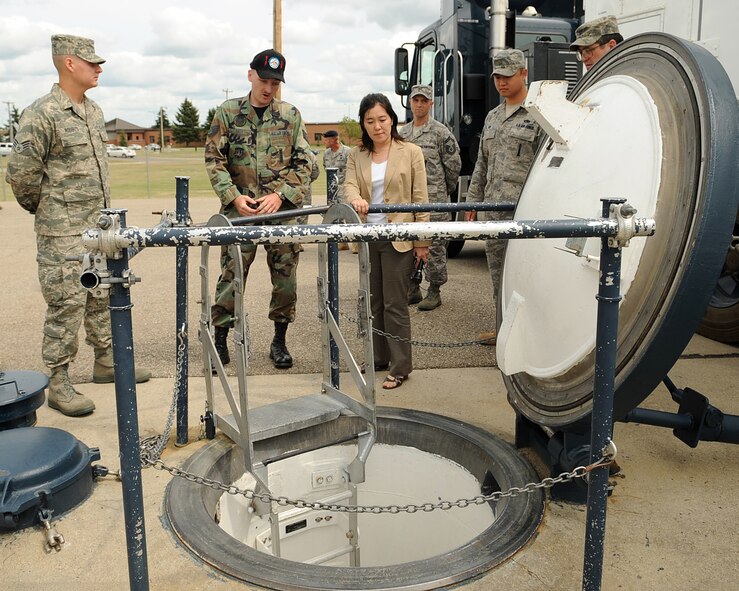 MINOT AIR FORCE BASE, N.D. -- Staff Sgt. Jason Keen (center left), a Missile Maintenance Team Instructor from the 91st Missile Operations Squadron, shows Ms. Noriko Kudo, a Bureau Chief from the Japan Broadcasting Corporation based in Los Angeles, the silo entry hatch during a top side tour of Uniform One here August 4, 2009. Ms. Kudo and two of her colleagues visited various areas on base to become familiarized with the nuclear reinvigoration process and tell the Minot Air Force base story to their viewer’s audience. (U.S. Air Force photo by Tech. Sgt. Linda C. Miller)