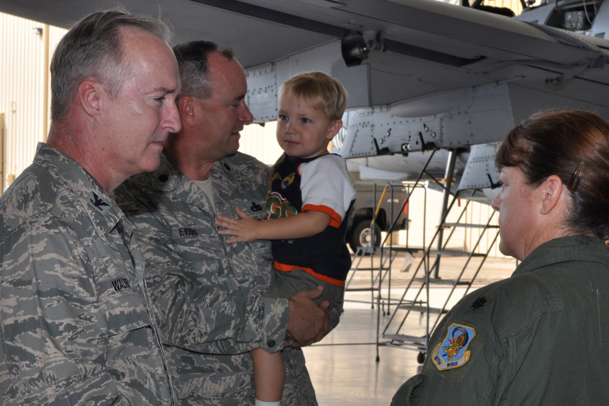 Lt. Col. Chris D. Evers entertains his son Aaron as Colonel Edmund Walker, commander, 917th Wing, Barksdale AFB, La., speaks with Lt. Col. Sharon Evers, 917th Medical Squadron, chief of aerospace medicine, before a change of command ceremony involving her husband in the A-10 hangar, at Barksdale Air Force Base, La., Sunday, August 2, 2009. Colonel Chris Evers relinquished command of the 717th Aircraft Maintenance Squadron to Maj. Michael R. Davis during the ceremony. (U.S. Air Force photo/Tech. Sgt. Jeff Walston)
