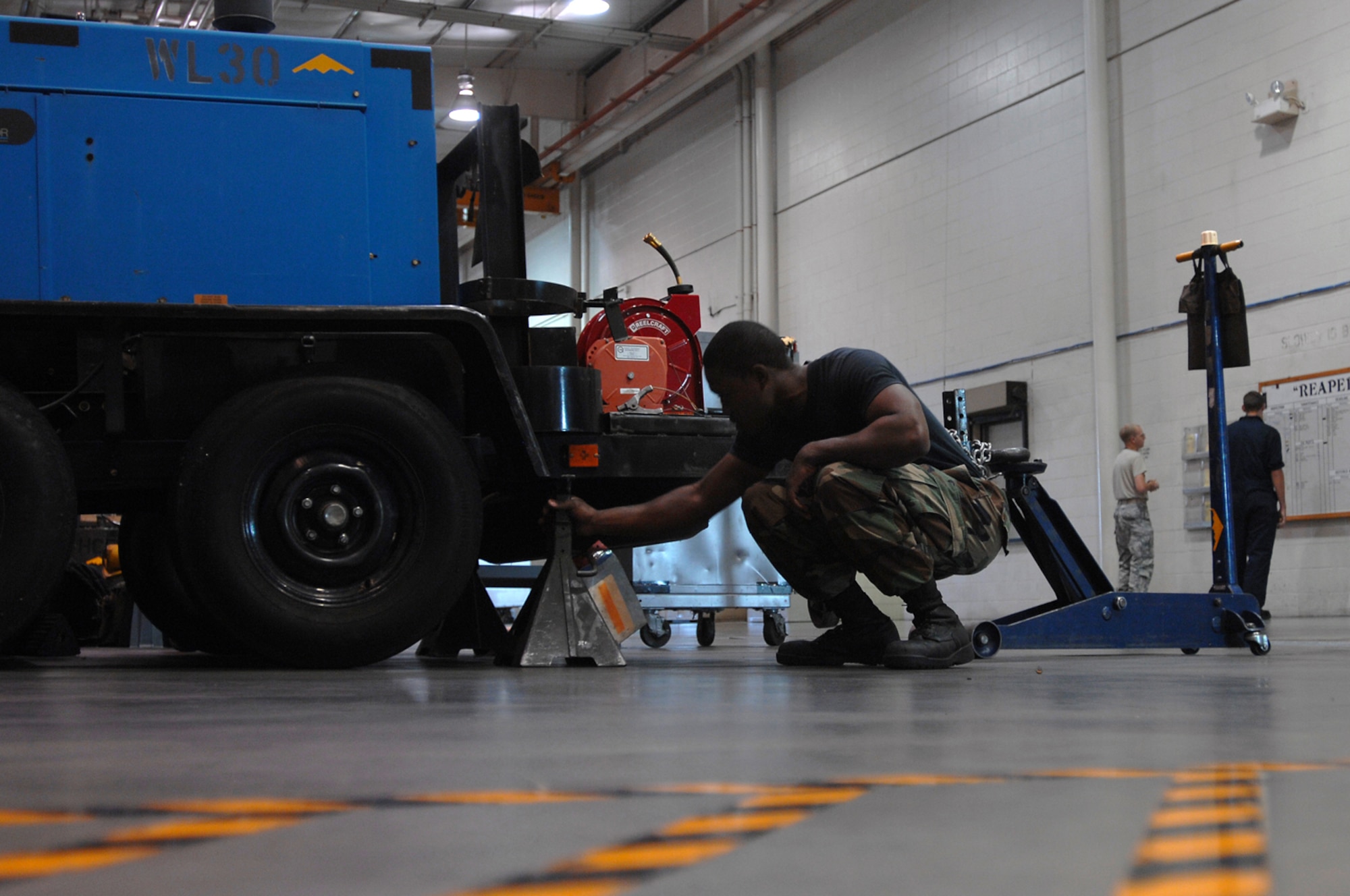 WHITEMAN AIR FORCE BASE, Mo. - Senior Airman Quintellis Darden, 509th Maintenance Squadron Aerospace Ground Equipment Mechanic, puts a floor jack in place before performing maintenance on a diesel welder. AGE mechanics perform anywhere between 40 to 60 hours of maintenance a week in support of the B-2 mission. (U.S. Air Force photo/Senior Airman Kenny Holston)