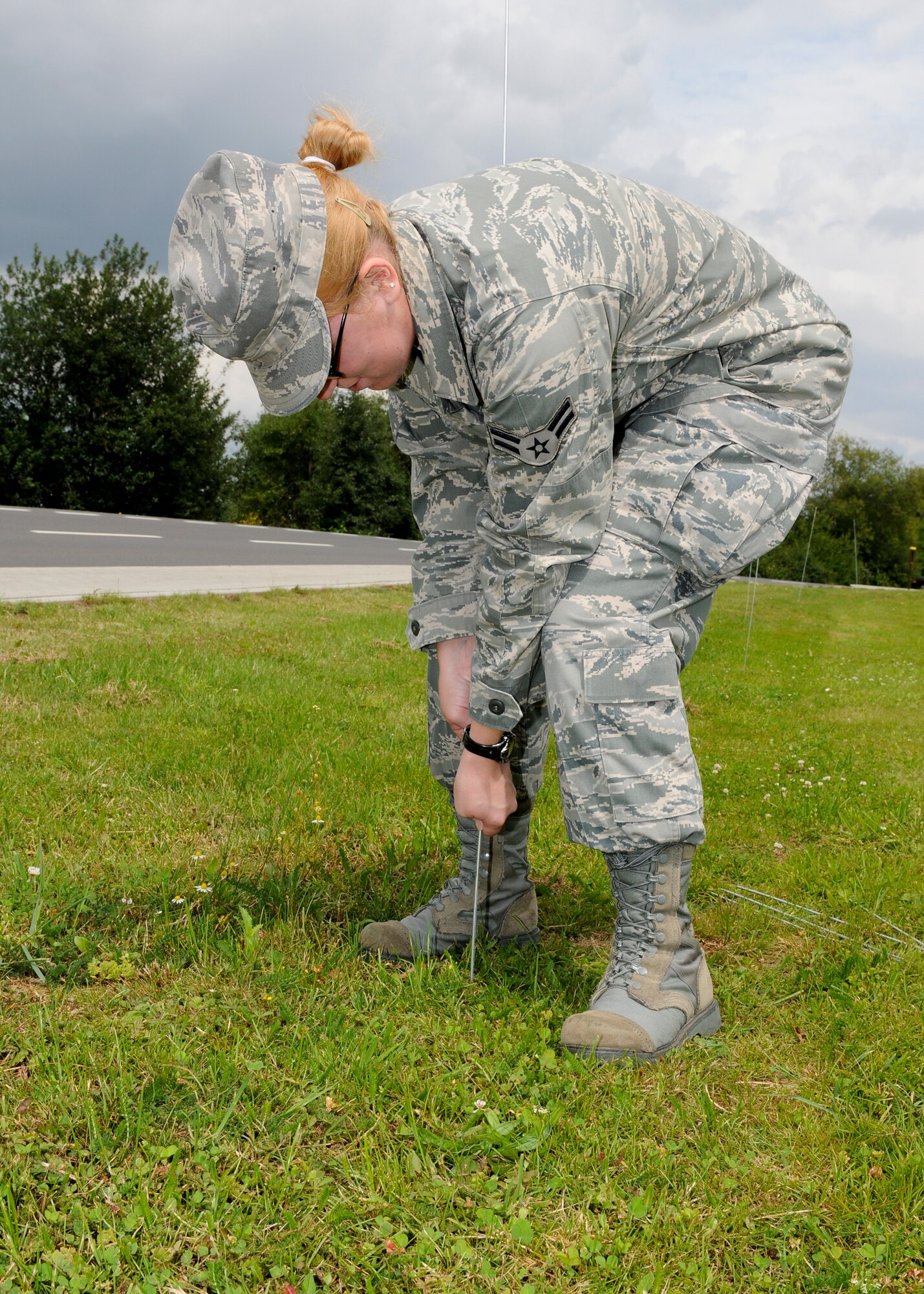 SPANGDAHLEM AIR BASE, Germany -- Airman 1st Class Christina Peabody, 52nd Medical Operations Squadron, prepares a cordon near the 81st Fighter Squadron Aug. 3 on Spangdahlem AB. The cordon was established to designate the boundaries of a simulated tactical area of responsibility for the upcoming Phase II exercise. The exercise will take place Aug. 4-7 in preparation for the 52nd FW’s NATO Tactical Evaluation next summer. (U.S. Air Force photo by Airman 1st Class Nathanael Callon)