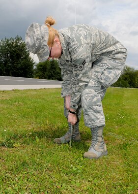 SPANGDAHLEM AIR BASE, Germany -- Airman 1st Class Christina Peabody, 52nd Medical Operations Squadron, prepares a cordon near the 81st Fighter Squadron Aug. 3 on Spangdahlem AB. The cordon was established to designate the boundaries of a simulated tactical area of responsibility for the upcoming Phase II exercise. The exercise will take place Aug. 4-7 in preparation for the 52nd FW’s NATO Tactical Evaluation next summer. (U.S. Air Force photo by Airman 1st Class Nathanael Callon)