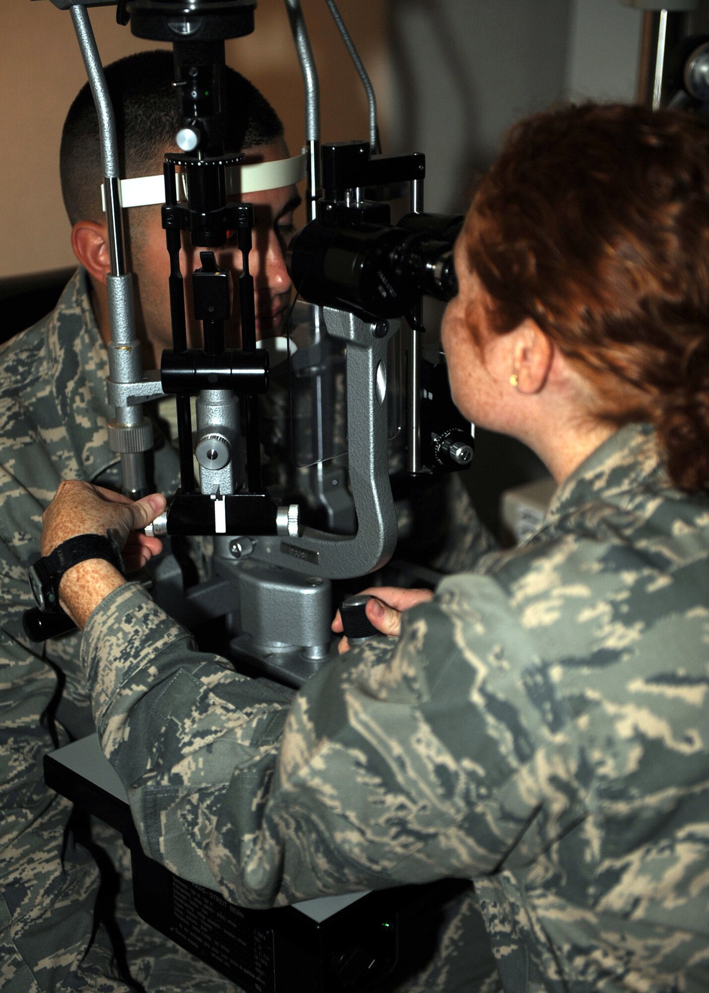 Captain Andrea Rope, 4th Medical Group optometrist, performs a slit-lamp exam on Airman 1st Class Gino Reyes, 4th Fighter Wing Public Affairs photographer at the optometry clinic on July 31, 2009. A slit-lamp exam is accomplished to help detect eye infection or injury to the cornea. (U.S. Air Force photo by Senior Airman Ciara Wymbs)