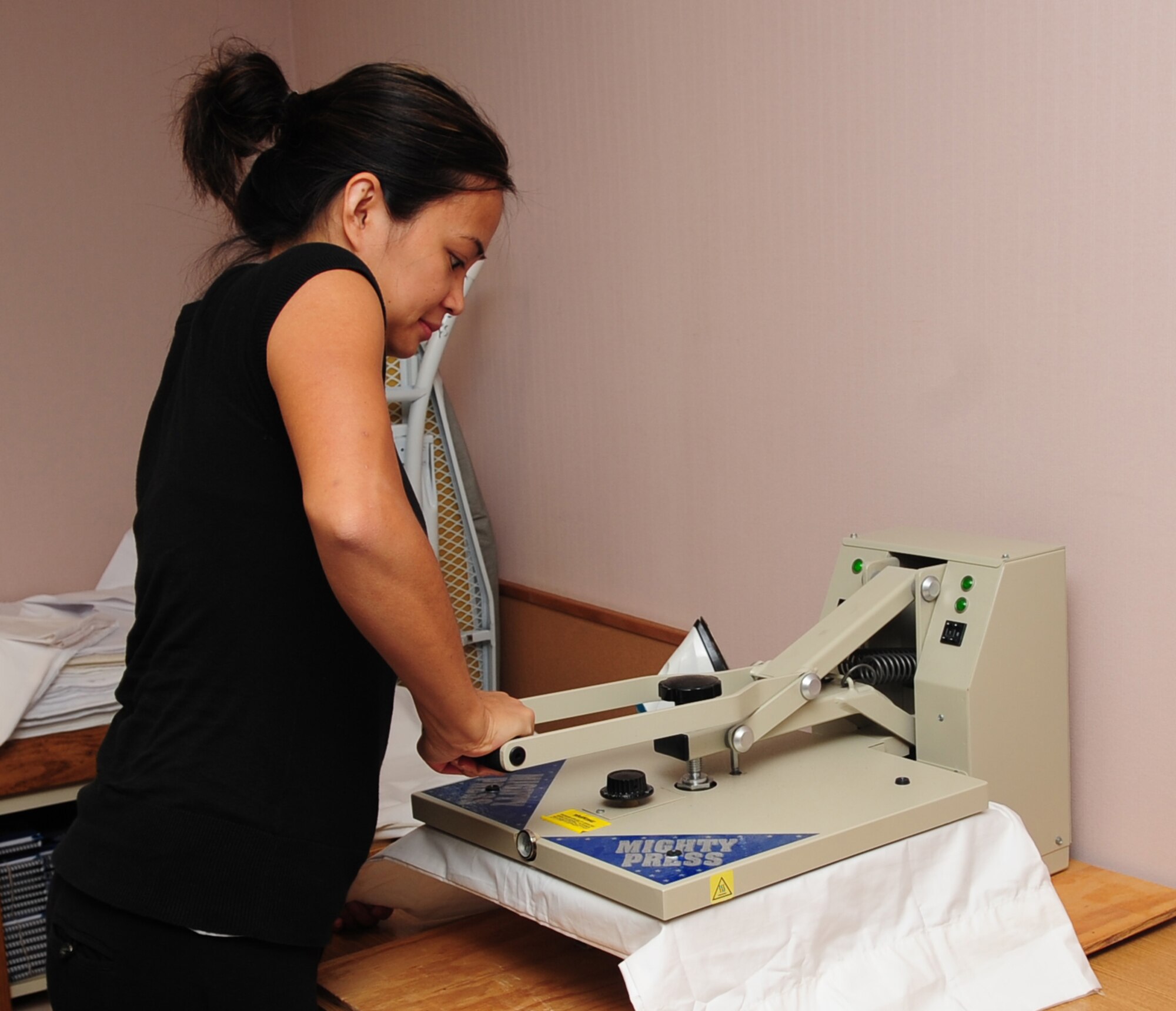 Mercy Nacpil, a volunteer at the Airman and Family Readiness Center, presses an iron-on photo to a REST pillow case on Seymour Johnson Air Force Base, N.C., August 5, 2009. The iron she is using has to be 350 degrees Fahrenheit before it can transfer the photo to the pillow case. (U.S. Air Force Photo by Airman 1st Class Rae Perry)