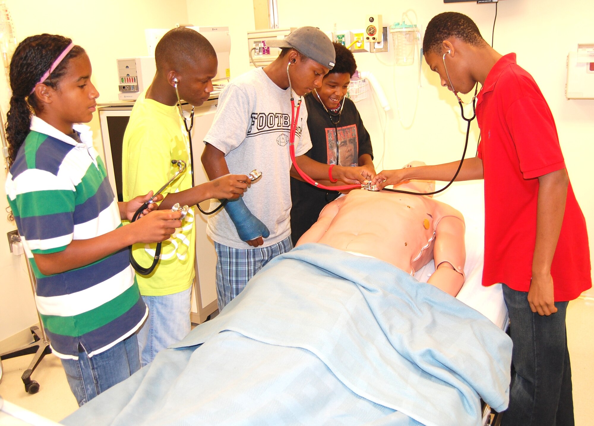 From left, Arcell Toler, 13; Daron Goudy, 15; Tre McBeath, 15; Isaiah Toler, 12 and Justin Hollimon, 17, listening to the breath sounds of one of the patient simulators.  (U.S. Air Force photo by Steve Pivnick)
