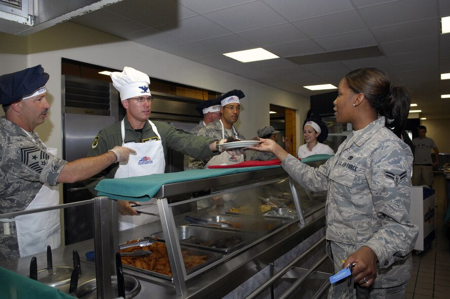 MINOT AIR FORCE BASE, N.D. -- Col. Julian Tolbert, 5th Bomb Wing vice commander, hands over a plate of freshly prepared food to Airman 1st Class Shonda Dixon, 5th Logistics Readiness Squadron, traffic management apprentice, as part of the Airmen Appreciation meal here July 30. Col. Tolbert, along with group commanders, first sergeants and chiefs, served Airmen from across the base at the Dakota Inn dining facility to show their gratitude for the service and dedication here. (Official U.S. Air Force photo by Airman 1st Class Jesse Lopez)