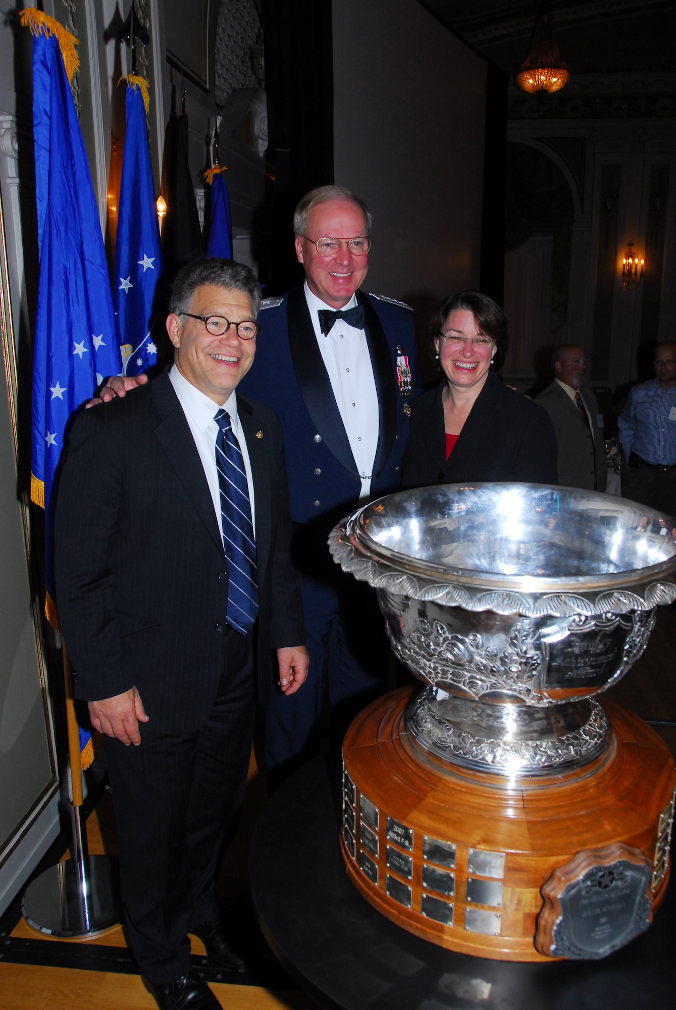 U.S. Air Force General Craig R. McKinley-Chief, National Guard Bureau, (center) poses with U.S. Senators Al Franken and Amy Klobachar after the presentation to the 148th Fighter Wing, Duluth, Minn. of the prestigious Raytheon Trophy July 31, 2009 in Duluth, Minn.  The Raytheon Trophy was awarded to the 179th Fighter Squadron of the 148th Fighter Wing as the most outstanding air defense unit in the U.S. Air Force, marking only the fourth time an Air National Guard unit received this award since its inception in 1953.  (U.S. Air Force photo by Tech. Sgt. Brett R. Ewald) 