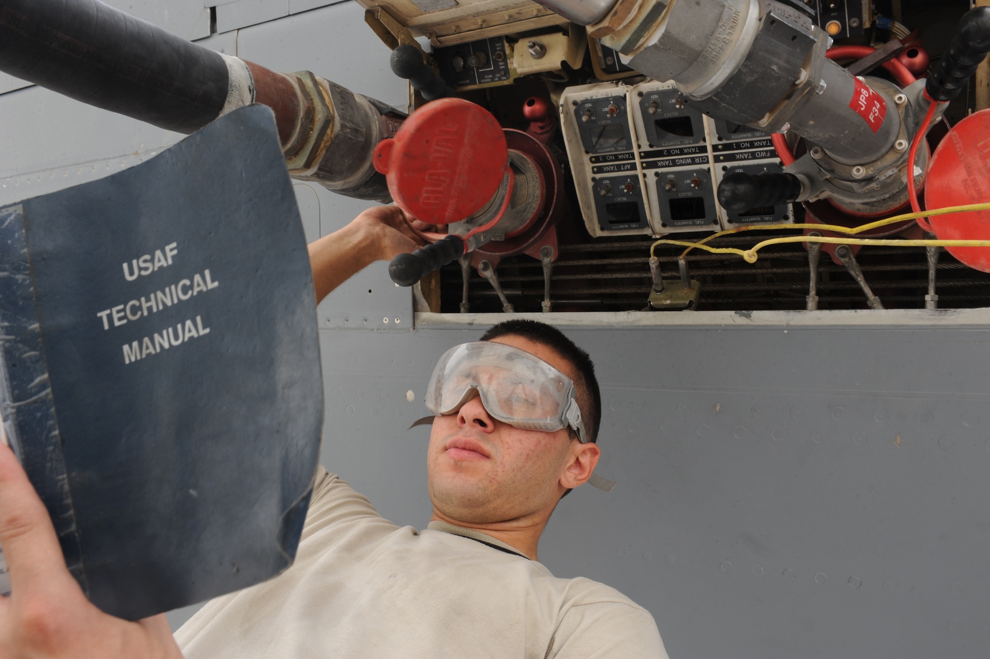 SOUTHWEST ASIA - Airman 1st Class Paul Fillips, 380th Expeditionary Aircraft Maintenance Squadron, reads an Air Force technical order during the refuel of a KC-10 aircraft Aug 3. Airman Fillips is a Crew Chief from McGuire Air Force base, N.J., and hails from Silver Lake, Mich. (U.S. Air Force photo Tech. Sgt. Charles Larkin Sr.)