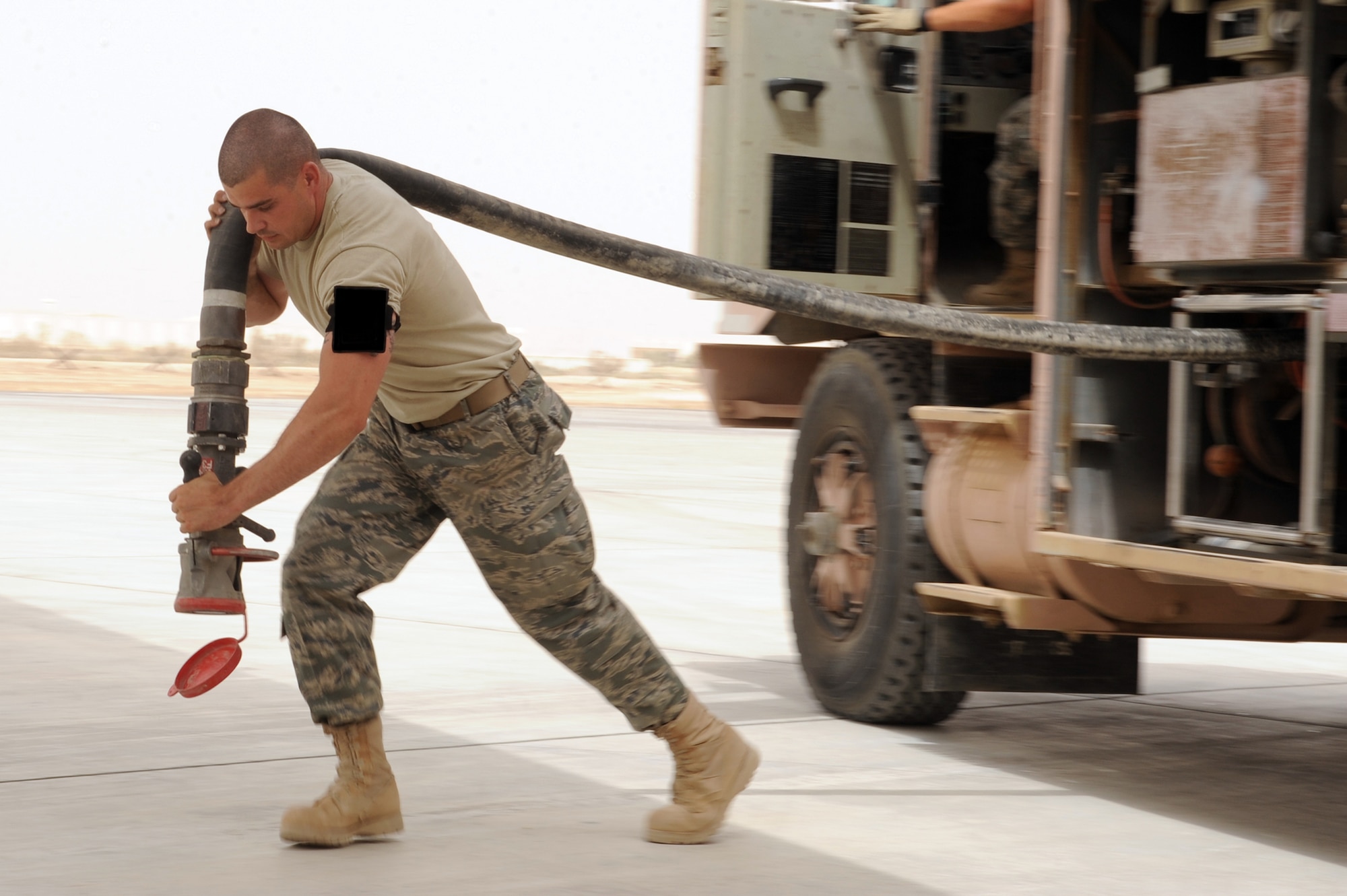 SOUTHWEST ASIA - Staff Sgt. Thomas Little, 380th Expeditionary Logistics Readiness Squadron, unreels a fuel hose in preparation to refuel a KC-10 aircraft Aug 3. Sergeant Little is a fuel control systems accountant from Minot Air Force base, N.D., and hails from Phoenix, Ariz. (U.S. Air Force photo Tech. Sgt. Charles Larkin Sr.)
