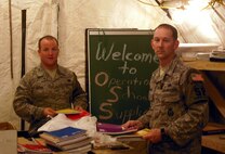 Master Sgt. Raymond Mooney and Staff Sgt. James Black, reservists with the 512th Airlift Wing, distribute Operation School Supplies to local Iraqi children at Kirkuk Regional Air Base, Iraq. The program allows people in the United States to send school supplies overseas where military members then give them to local children. Sergeants Mooney and Black, along with 10 members of the 512th Security Forces Squadron, returned from a deployment to Kirkuk AB in July. (U.S. Air Force photo/Capt. Marnee A.C. Losurdo)