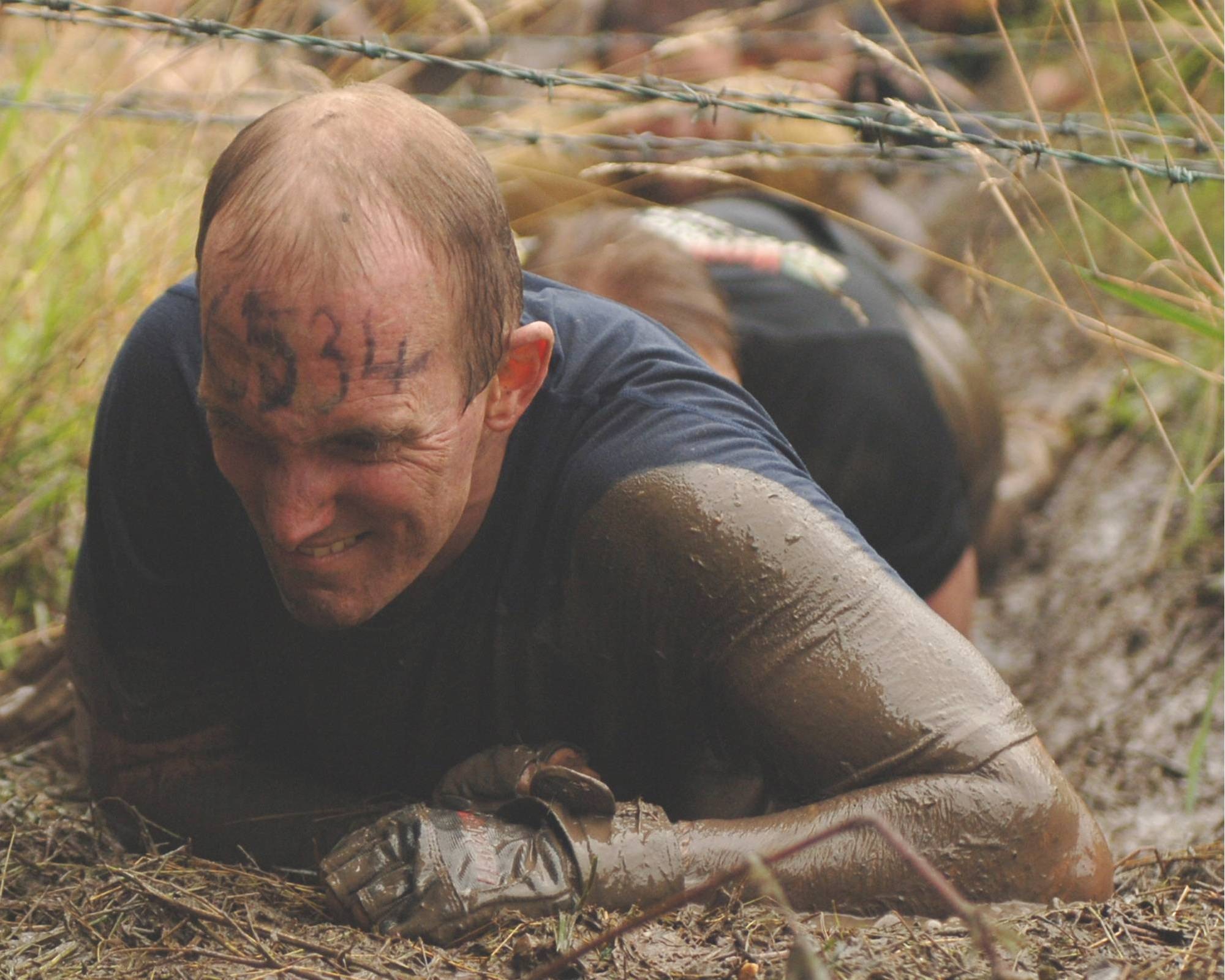 JAC Navy Chief Petty Officer Steven L. Shultz crawls through a barbed wire obstacle during the UK TOUGH GUY summer 2009 competition in Perton, England.  The Chief was part of the nine member JAC HAMMERS team which competed against other military and civilian teams from the UK and Europe. (U.S. Air Force photo by Staff Sgt. Rachel Goff)