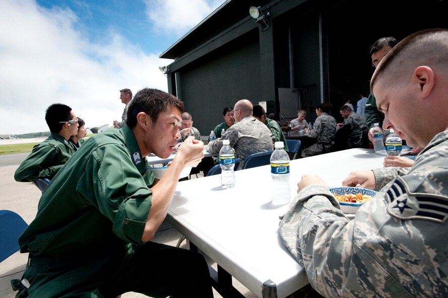 MISAWA AIR BASE, Japan -- Participants in the Japan Air Self-Defense Force and U.S. Air Force bi-lateral exchange share a meal of chili and hot dogs at the 35th Maintenance Squadron Aerospace Ground Equipment Flight July 31 at the AGE Flight headquarters. The JASDF members were invited to the chili cook-off to get a spicy taste of American culture during their visit. (U.S. Air Force photo by Staff Sgt. Samuel Morse)