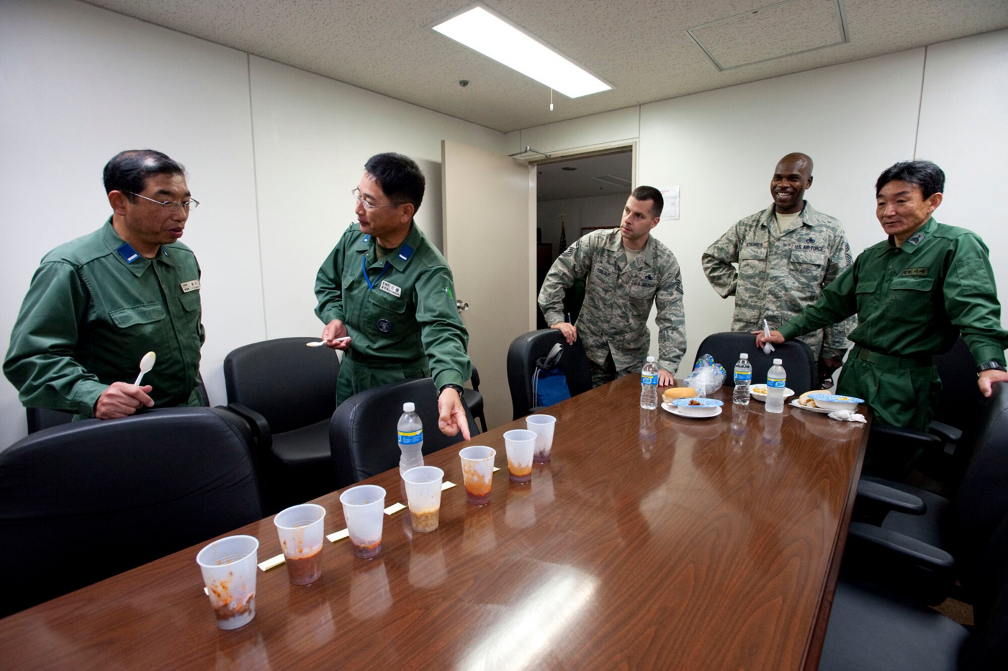 MISAWA AIR BASE, Japan -- Japan Air Self-Defense Warrant Officers Tagawa Tsuyoshi and Masato Kawabata taste-test various chilies prepared by members of the 35th Maintenance Squadron, Aerospace Ground Equipment Flight, July 31 at the AGE Flight headquarters. The chili made by Tech. Sgt. William Wells, vehicle NCO in charge, was declared the winner. (U.S. Air Force photo by Staff Sgt. Samuel Morse)