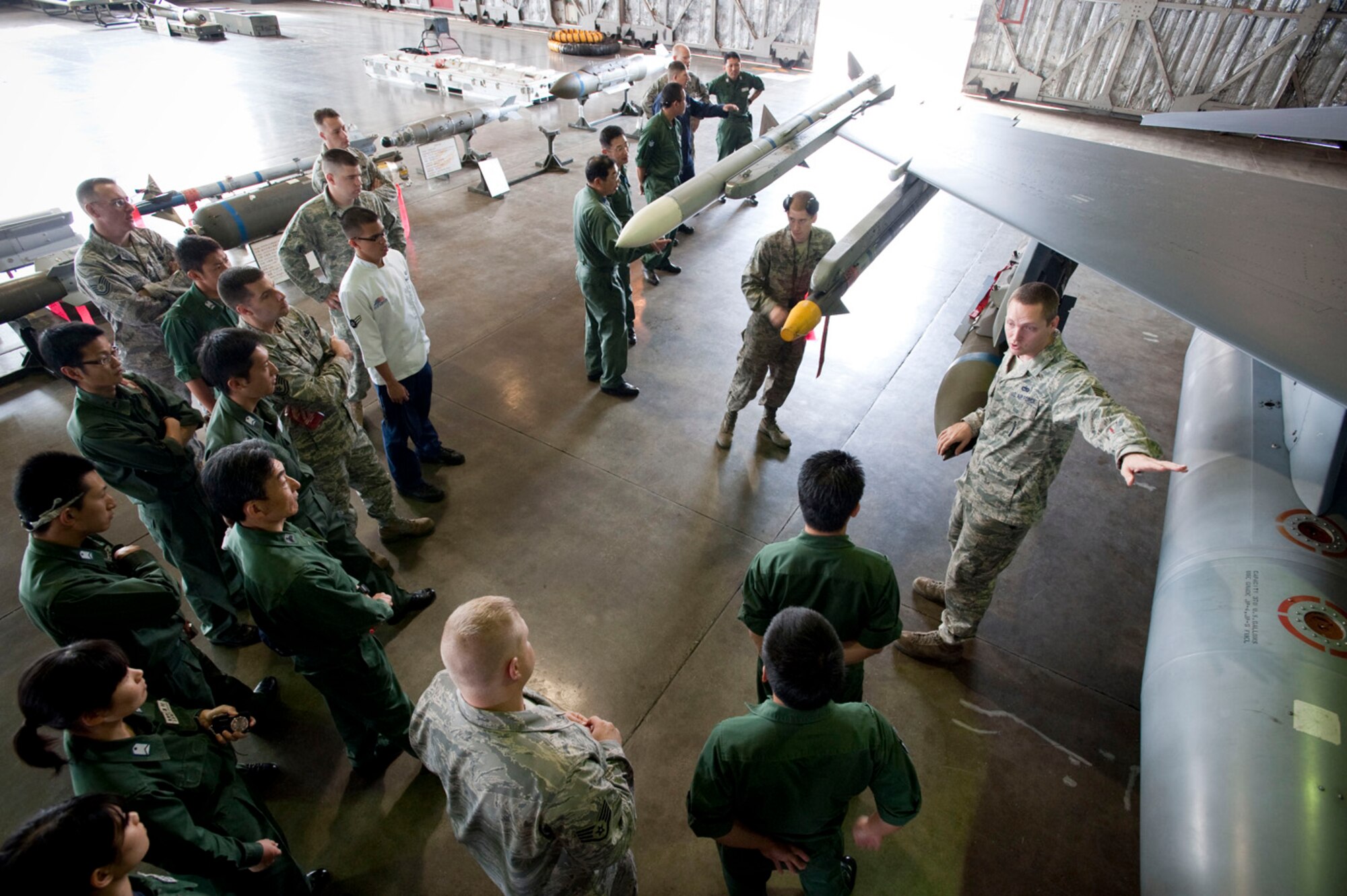 MISAWA AIR BASE, Japan -- Staff Sgt. Jason Bouse, 35th Maintenance Operations Squadron weapon loads crewman, shows a group of Japan Air Self-Defense Force and U.S. Air Force Airmen the types of weapons typically loaded on an F-16 Fighting Falcon July 31 in Hangar 911. This guided tour was part of a bi-lateral exchange with the JASDF to help them understand how the U.S. Air Force operates. (U.S. Air Force photo by Staff Sgt. Samuel Morse)