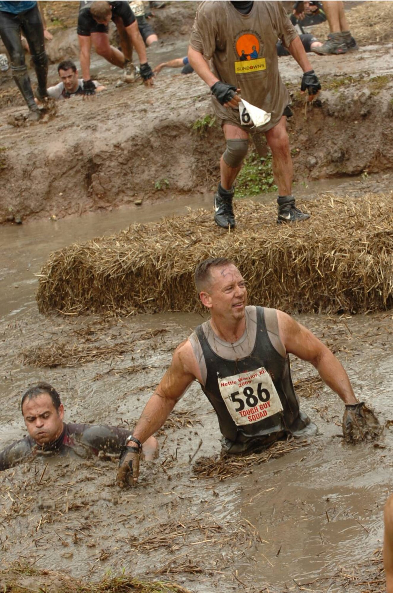 JAC Commander Marine Corps Col. Pete Devlin and LT Jose Lepesuastegui (on his right) navigate a water obstacle during UK TOUGH GUY summer 2009 in Old Perton, England.  For the Col. it is his third TOUGH GUY and the fourth for the LT.  (U.S. Air Force photo by Staff Sgt. Rachel Goff)