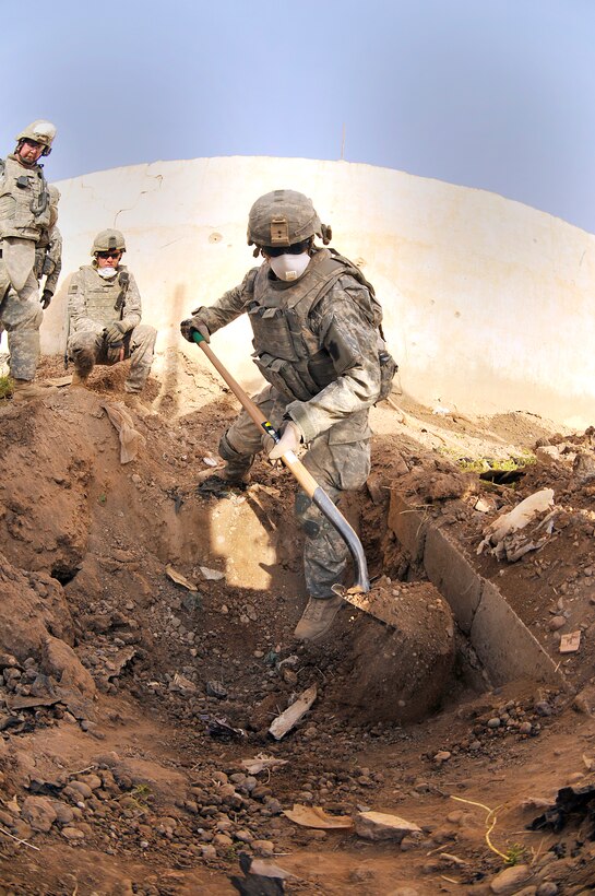A U.S. Army soldier uses a shovel to dig through dirt and rubble to search for the remains of a U.S. servicemember missing in action since 2003 in Baghdad, Aug. 3, 2009.