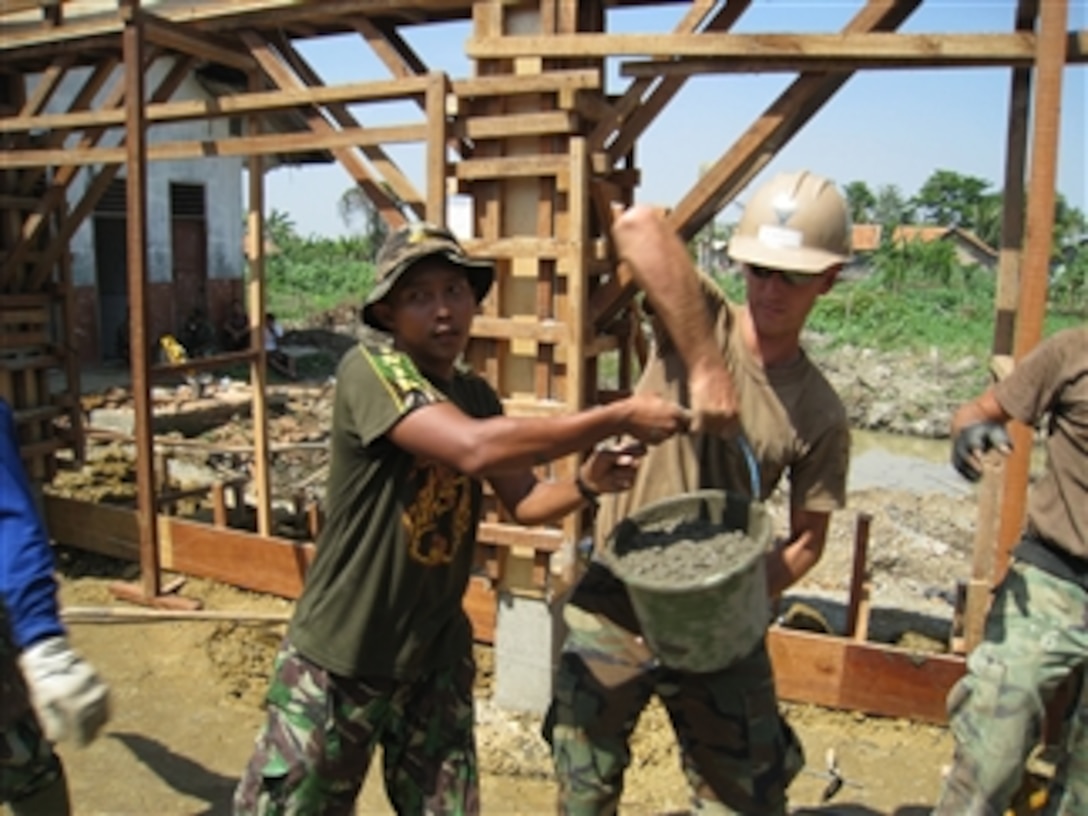 U.S. Navy Seabees from Naval Mobile Construction Battalion 40 and Indonesian marine corps engineers transfer concrete at the site of an engineering civic action program in Bekasi, Indonesia, on July 29, 2009.  The engineering civic action program held at Pusaka Rakyat Primary School is part of the first phase of Cooperation Afloat Readiness and Training Indonesia 2009, a series of bilateral exercises held annually in Southeast Asia.  