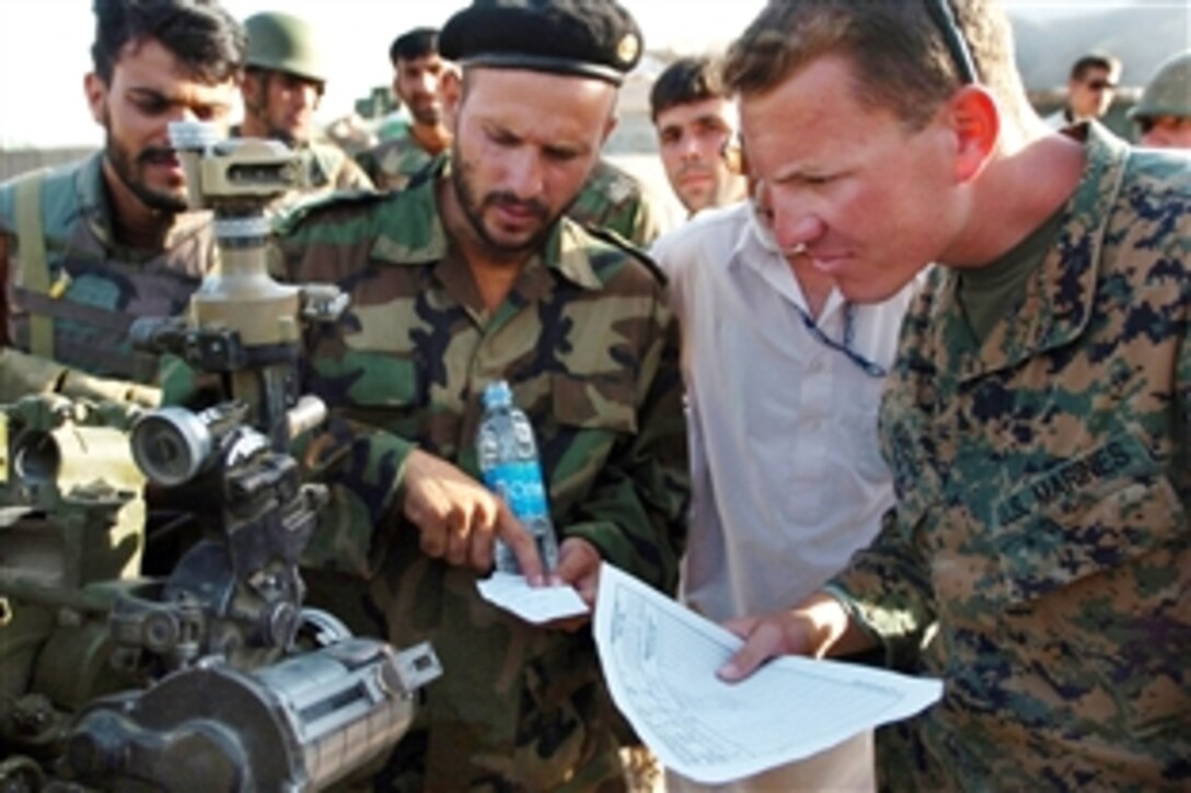 U.S. Marine Corps 1st Lt. Steve Murello listens as an Afghan officer explains the coordinates used during a live-fire exercise incorporating the Afghan army’s 4th Kandak forward observers, fire direction control personnel and artillerymen on Forward Operating Base Kalagush in Afghanistan’s Nuristan province, Aug. 2, 2009. Murello is a member of the Embedded Training Team 4-4.