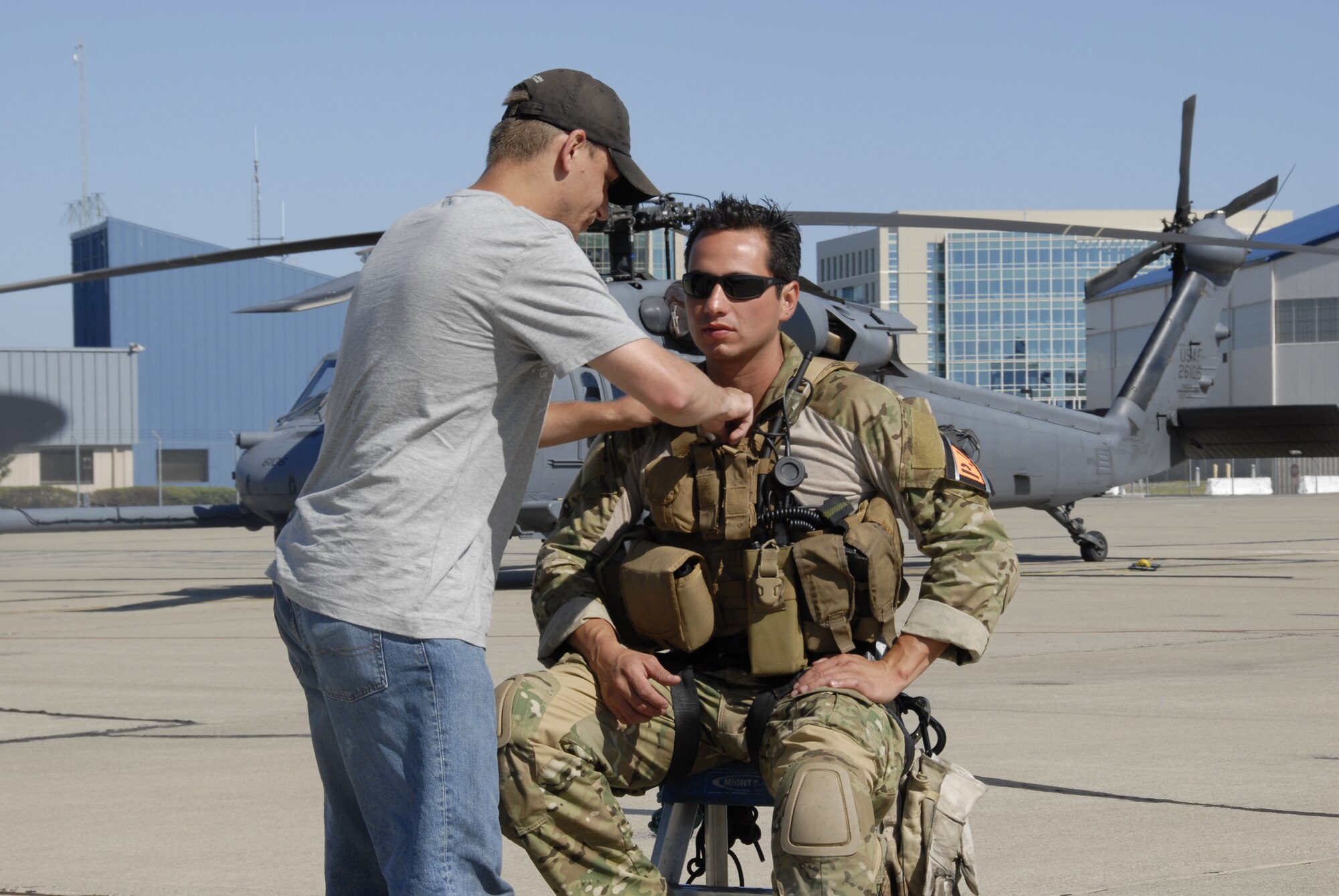 Tech. Sgt. Mike Davis, photographer for the Air National Guard Advertising and Marketing Creative Branch, puts a lapel microphone on Tech. Sgt. Luigge Romanillo, a pararescueman from the 131st Rescue Squadron, in preparation for an interview at Moffett Federal Airfield, Calif., with the Air National Guard Advertising and Marketing team during a video shoot for the redesign of GoANG.com, Aug. 5, 2009.  (Air National Guard photo by Tech. Sgt. Ray Aquino)