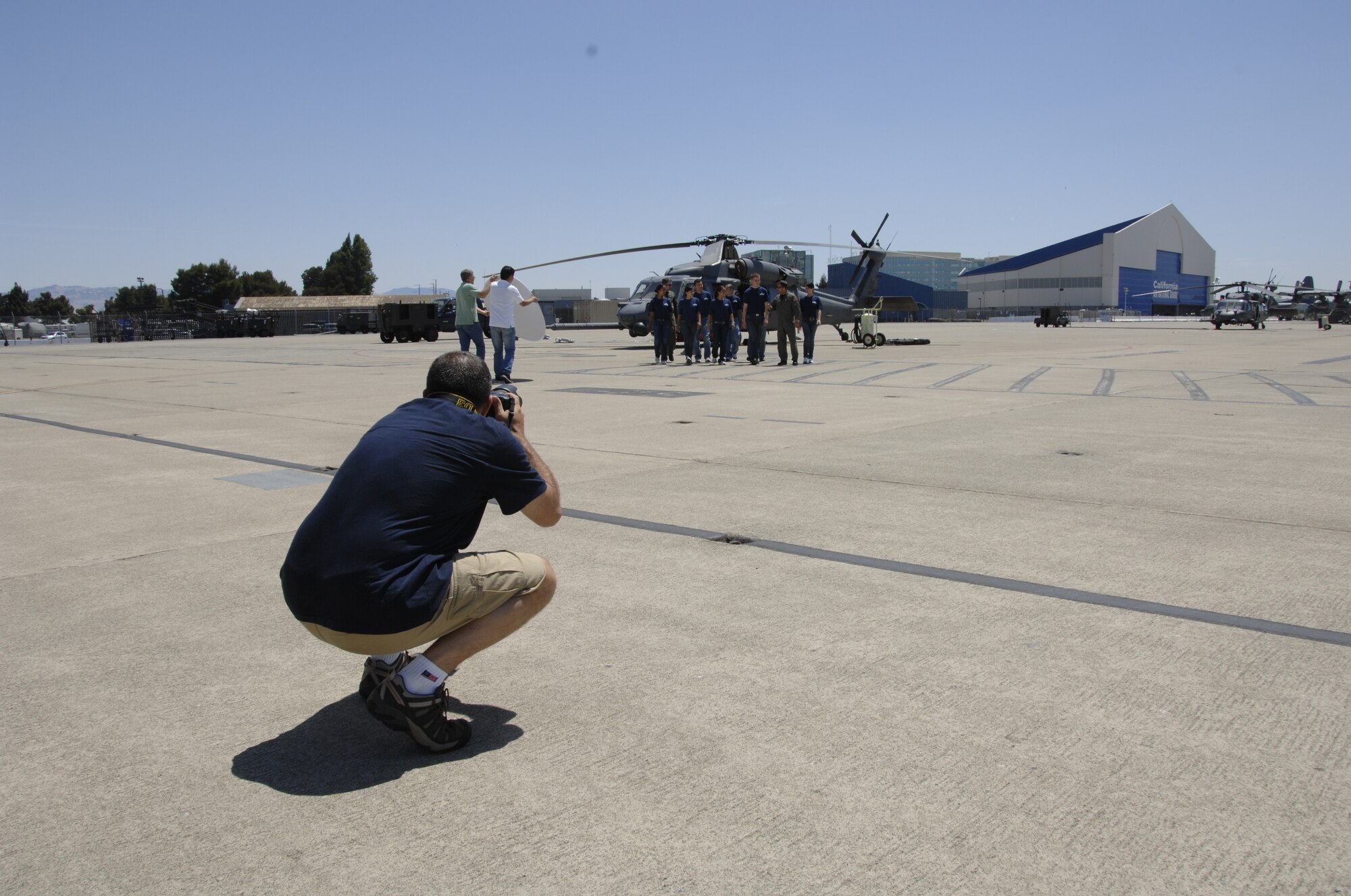 Master Sgt. Rob Trubia, superintendent of the Air National Guard Advertising and Marketing Creative Branch, takes photos of the 129th Rescue Wing student flight during a photo shoot for the redesign of GoANG.com at Moffett Federal Airfield, Calif., Aug. 1, 2009. (Air National Guard photo by Tech. Sgt. Ray Aquino)