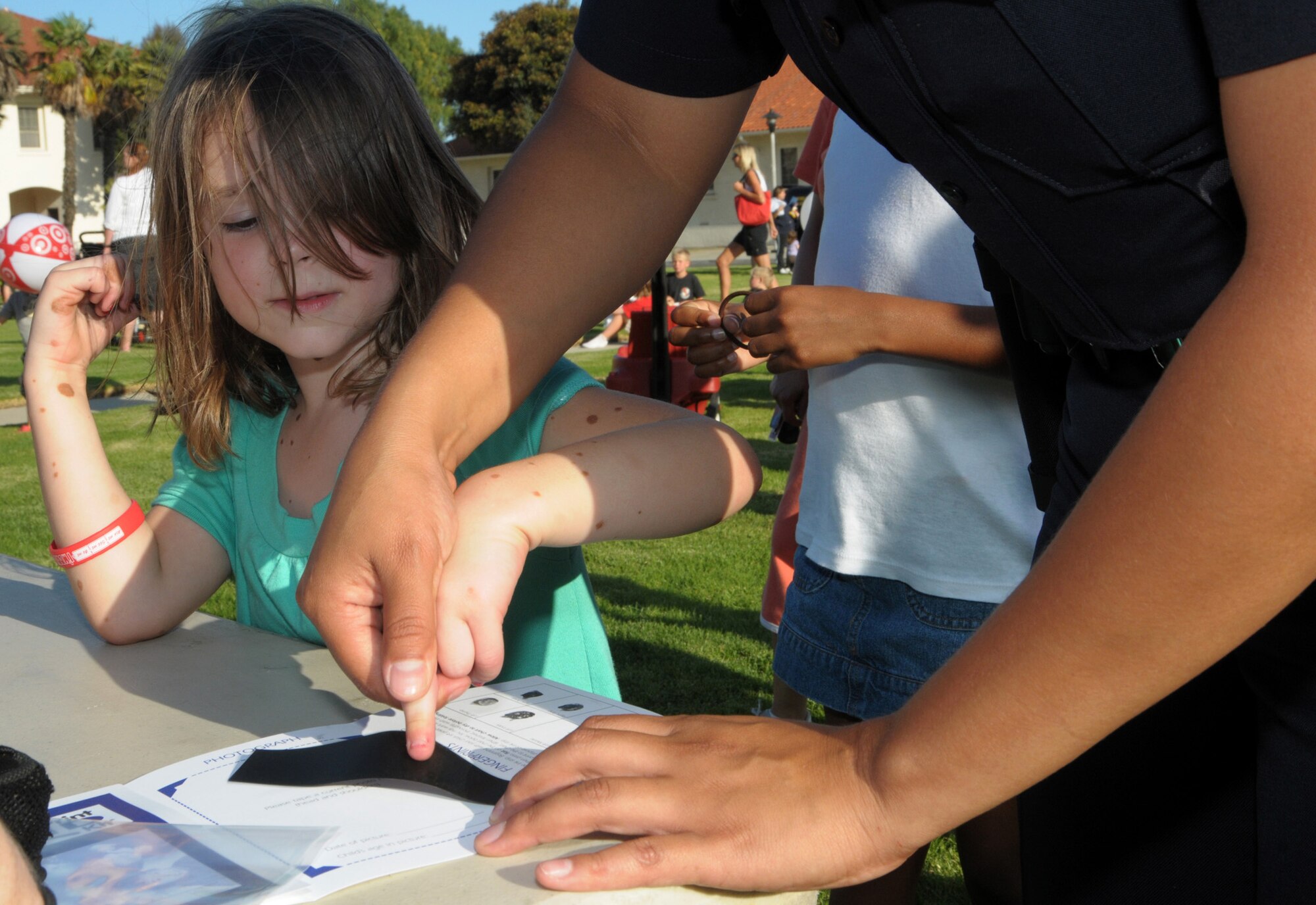 Family Member Mackenzie Fox gets finger printed at the National Night Out event at Fort MacArthur, Aug. 4. Families gathered to enjoy food, meet Mc Gruff the Crime Dog and local fire department reps, and other activities in observance of the event where neighborhoods across the country take back the night from crime.  (Photo by Joe Juarez)