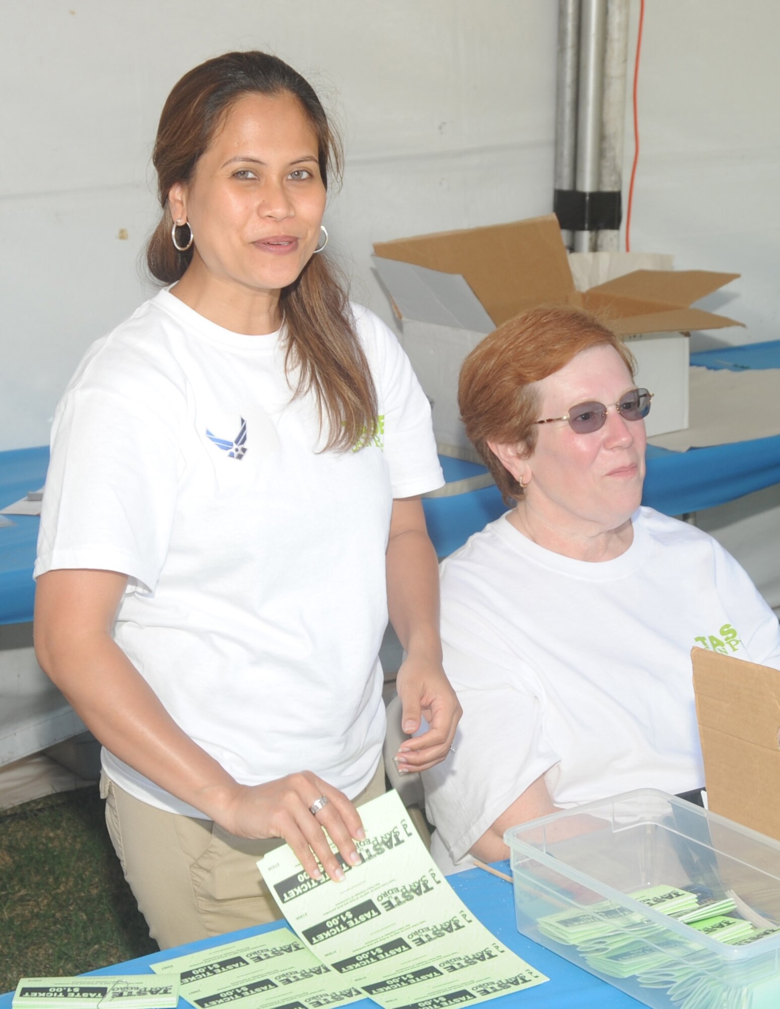 Staff Sgt. Rhea Lora, 61st Medical Group, sells tickets at the annual Taste in San Pedro, Aug. 2. Approximately 50 LAAFB airmen, civilians and their families volunteered at this year’s event. (Photo by Atiba S. Copeland)