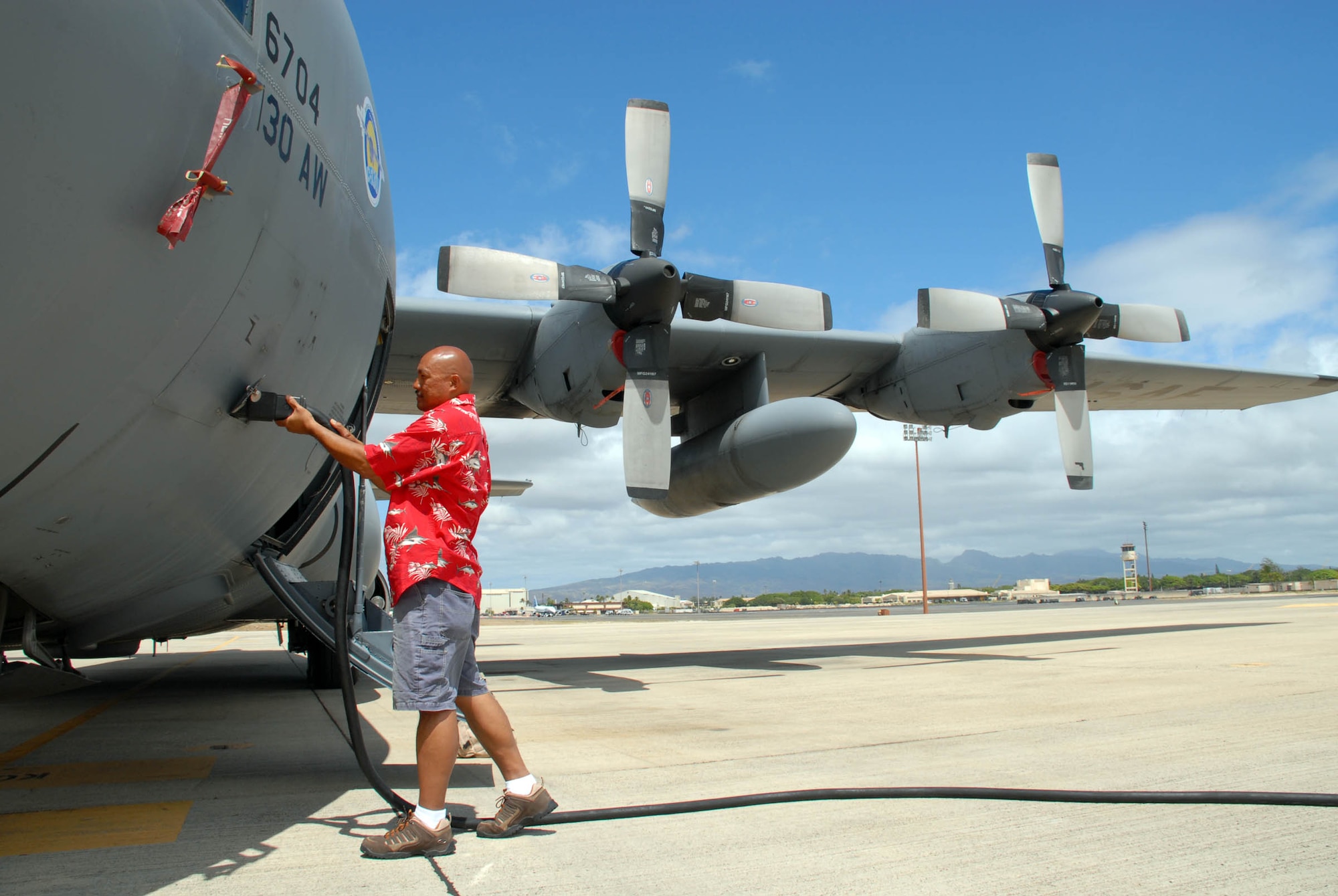 HICKAM AIR FORCE BASE, Hawaii -- Miguel Alcantara Ribancos, 912th Aircraft Maintenance Squadron production superintendent, Edwards Air Force Base, Calif., hooks up a C-130 to a power generator on the flightline here Aug. 4. The aircraft, which was recently converted from analog systems to digital, landed here during an eight-day integrated systems evaluation. They flew across international datelines and the equator to ensure all the upgraded systems would operate smoothly.The conversion was in line with the Air Force’s avionics modernization program, and the Air Force plans to buy 265 of the upgraded C-130s once testing is complete. (U.S. Air Force photo/Staff Sgt. Carolyn Viss)