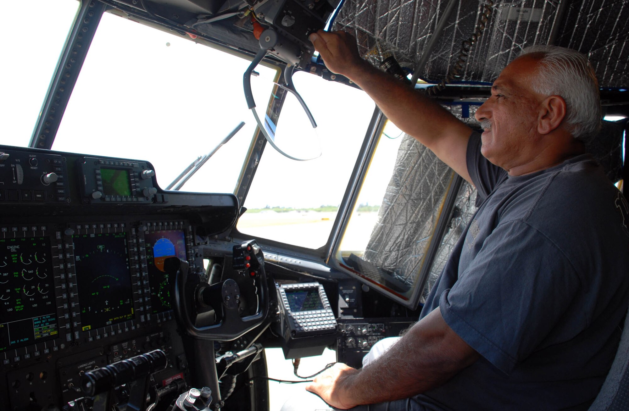 HICKAM AIR FORCE BASE, Hawaii -- Mo Redha, a Boeing avionics technician, adjusts the brightness on a heads-up display on an Edwards Air Force Base, Calif., C-130 on the flightline here Aug. 4. The aircraft, which was recently converted from analog systems to digital, landed here during an eight-day integrated systems evaluation. They flew across international datelines and the equator to ensure all the upgraded systems would operate smoothly.The conversion was in line with the Air Force’s avionics modernization program, and the Air Force plans to buy 265 of the upgraded C-130s once testing is complete. (U.S. Air Force photo/Staff Sgt. Carolyn Viss)