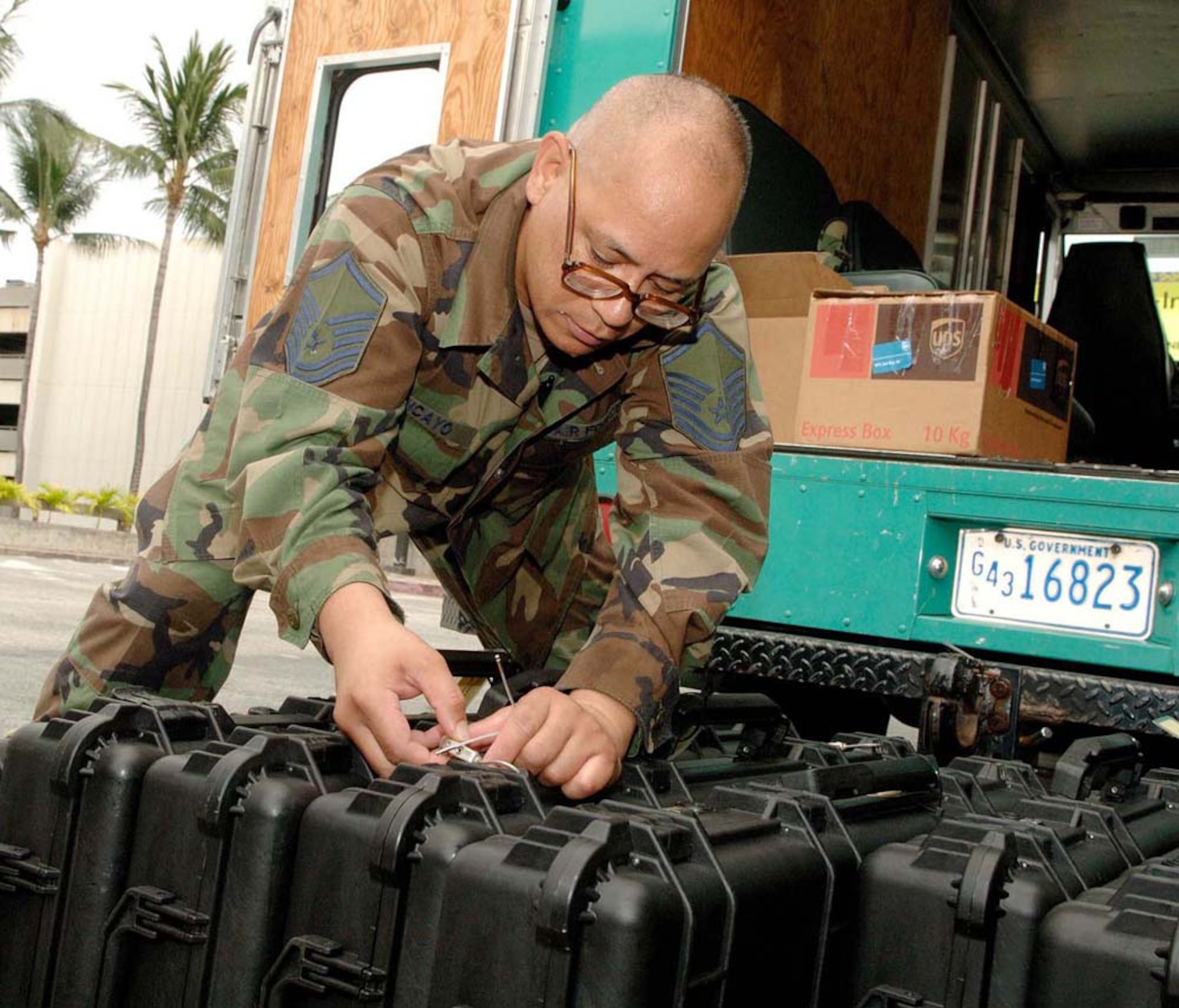 Master Sgt. Robert Tancayo, 624th Civil Engineer Squadron, inspects weapon cases before distributing them to reservists in his squadron July 31, 2009. Fifty-four reservists from the squadron were mobilized for six months and sent to Bagram Airfield, Afghanistan, to support the U.S. Army. (U.S. Air Force photo/Mark Bates)