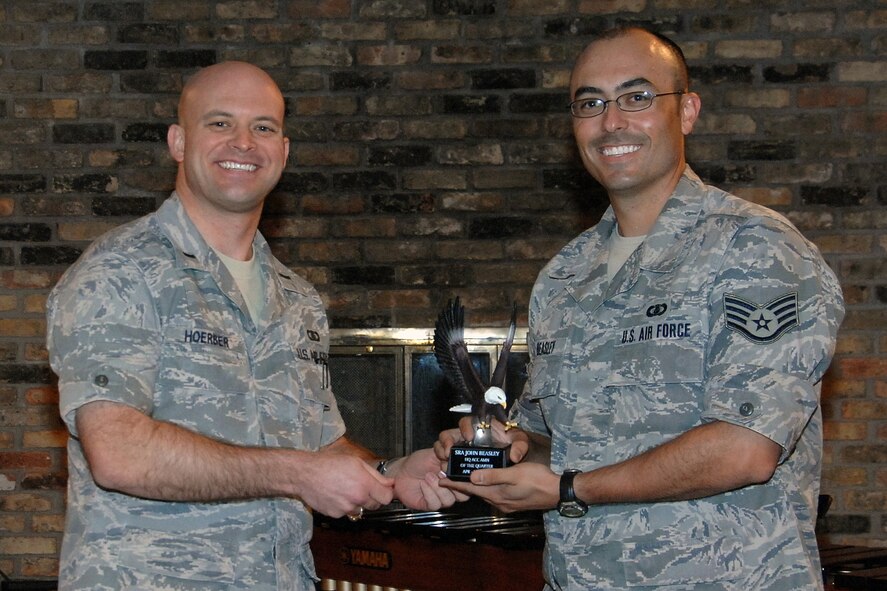 OFFUTT AIR FORCE BASE, Neb.-- 1st Lt. Michael Hoerber, commander of the Heartland of America Band, presents Staff Sgt. David Beasley, arranger for the Heartland of America Band, with the Airman of the Quarter Award for Air Combat Command headquarters during the Lunch Bachs concert on July 31. Sergeant Beasley will be seperating from the Air Force and attending the University of Nebraska-Lincoln Law School.