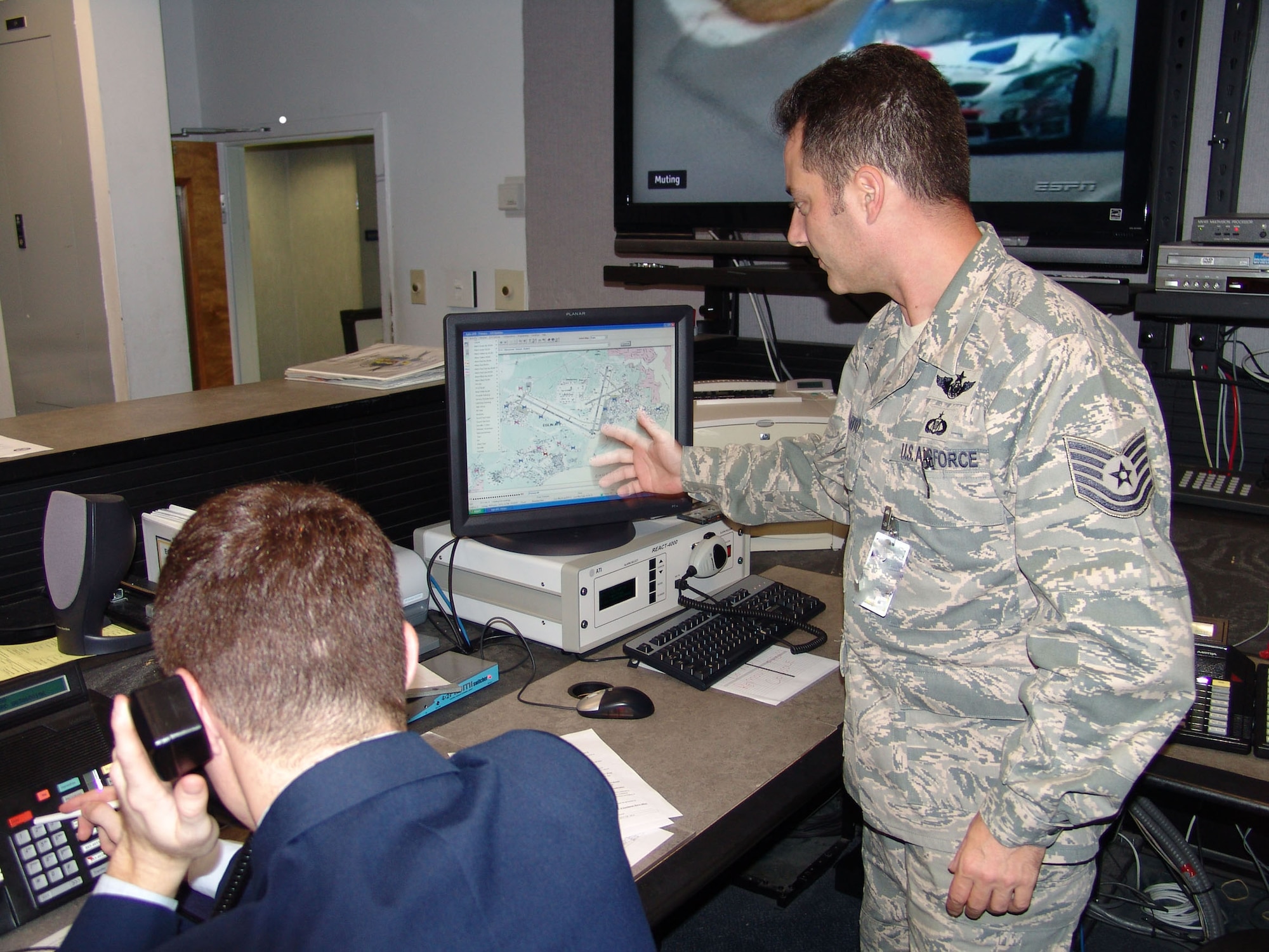 Tech Sgt. Christopher Galletto explains the At Hoc computer system that sends automated notifications with pop-up messages to more than 14,000 computers if there are weather warnings, exercise messages, or important information. (USAF photo/Lois Walsh)