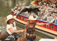 Airmen from the 344th Training Squadron pass behind NBC's Today Show hosts Hoda Kotb and Kathie Lee Gifford during the show's "Fun Texas Animals" segment. The Airmen represented the Air Force during the Today Show's live broadcast from San Antonio's Arneson River Theatre on the River Walk July 29. (U.S. Air Force photo/Robbin Cresswell)